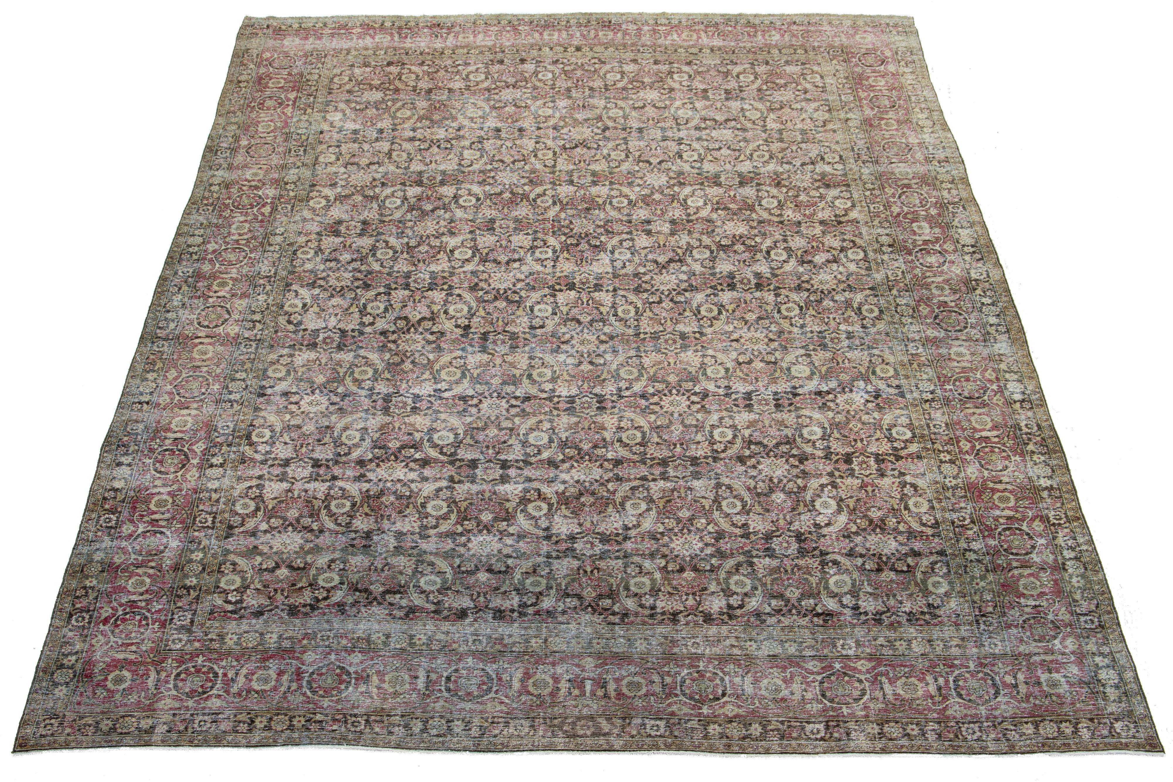 Ce tapis antique en laine nouée à la main et vieillie de Malayer présente un champ brun, complété par un motif all-over exquis rehaussé d'accents rouges et beiges.

Ce tapis mesure 10'8