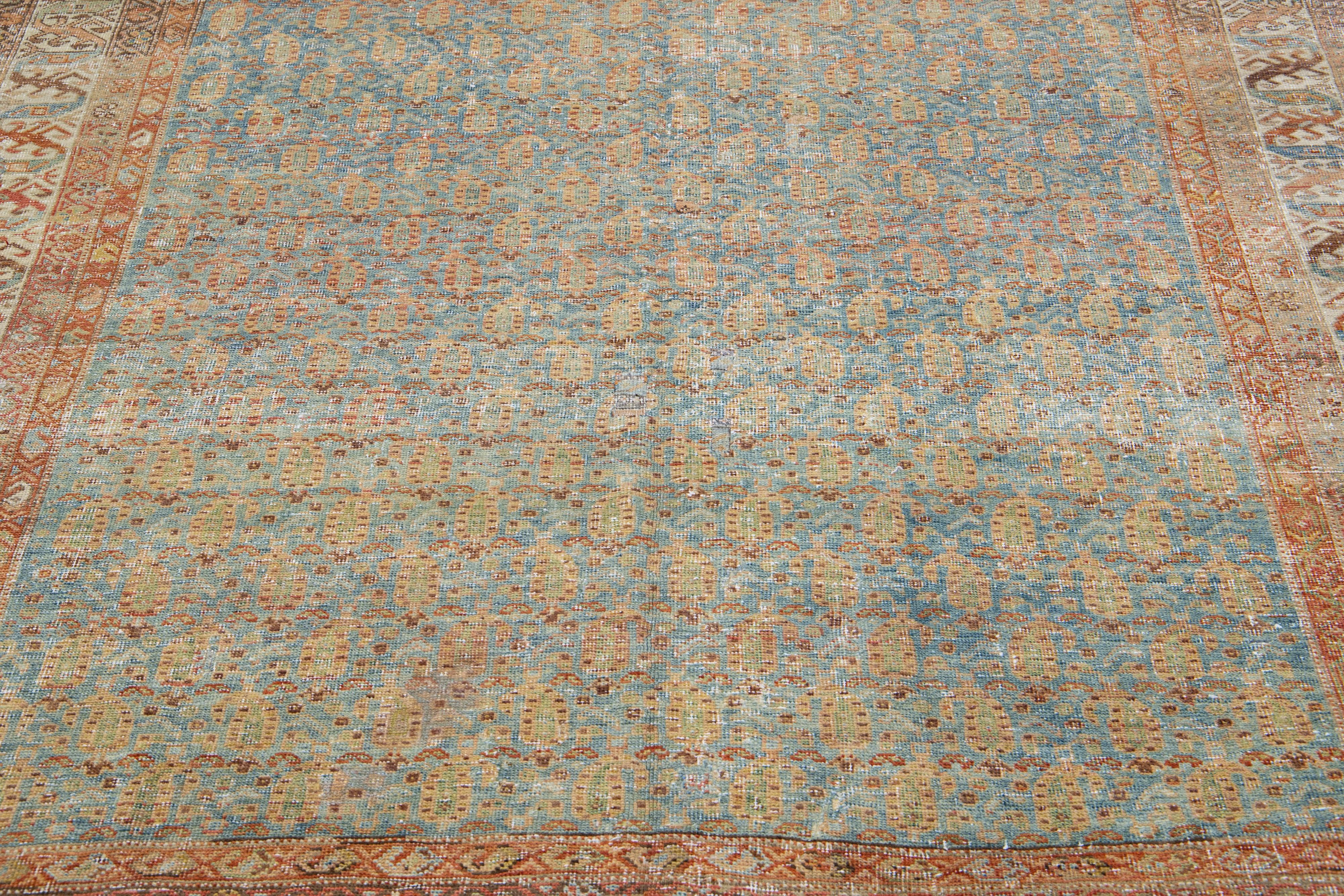 Beautiful antique Malayer hand-knotted wool rug with a blue color field. This Persian rug has orange-rust, brown, and green accents in a gorgeous traditional floral design.

This rug measures: 5'11