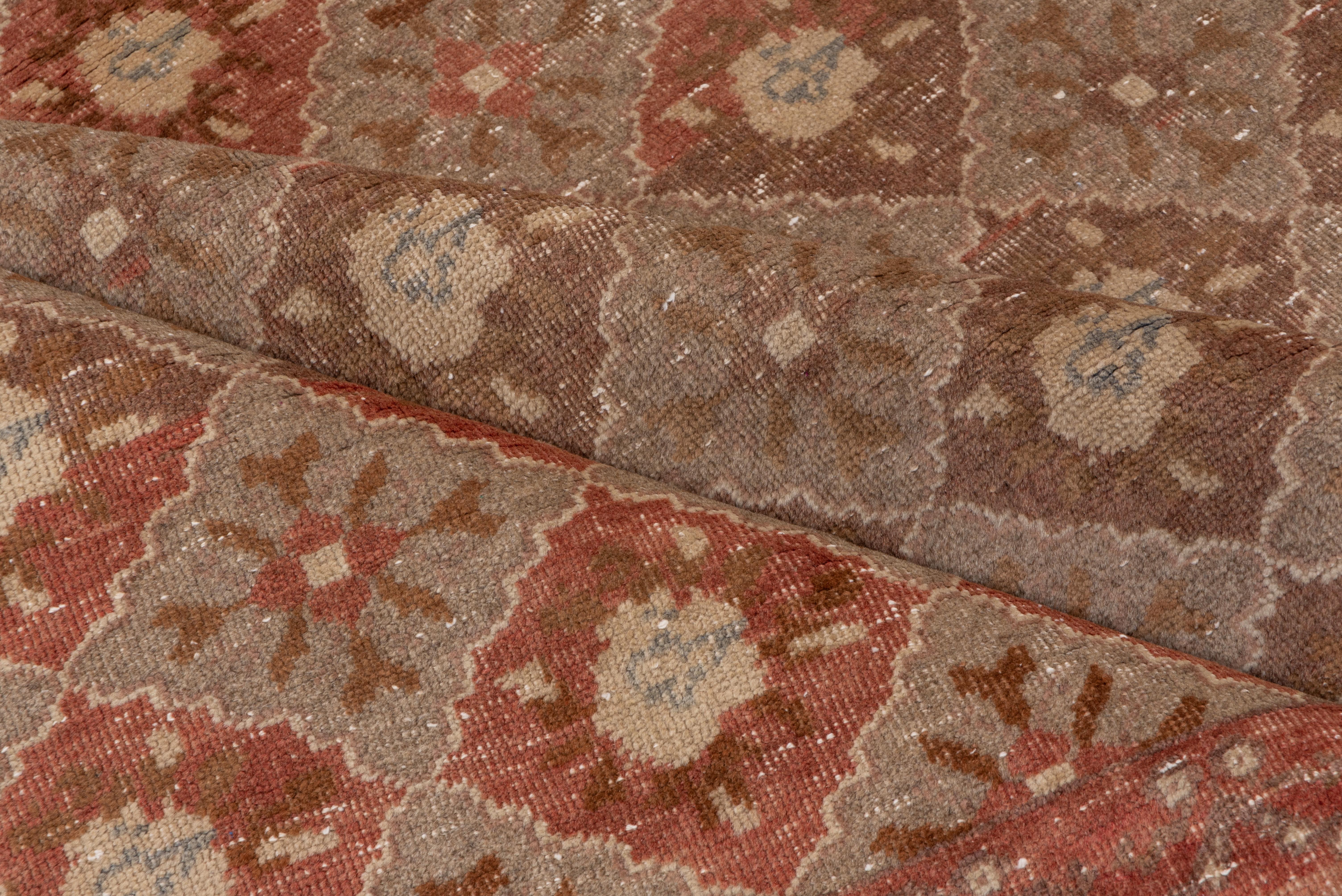 The light red and brown field shows seven columns of barbed rose tone barbed diamonds enclosing roughly drawn roses in a continuous textile pattern. Narrow semi-circular garland border.
  