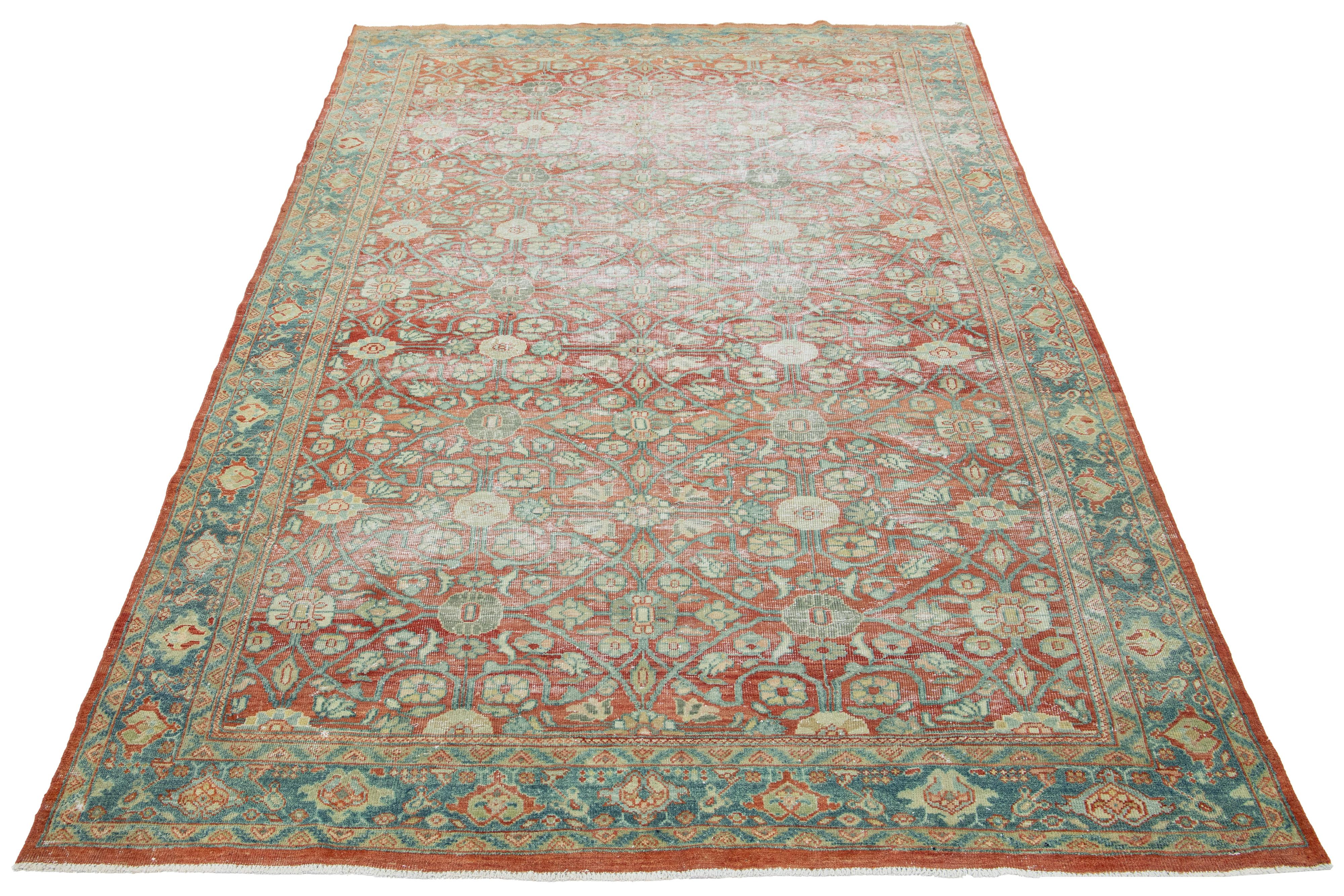 This Persian Tabriz wool rug is handcrafted with an all-over floral pattern in peach, light blue, and beige, on a red background that accentuates the design.

This rug measures  6'6