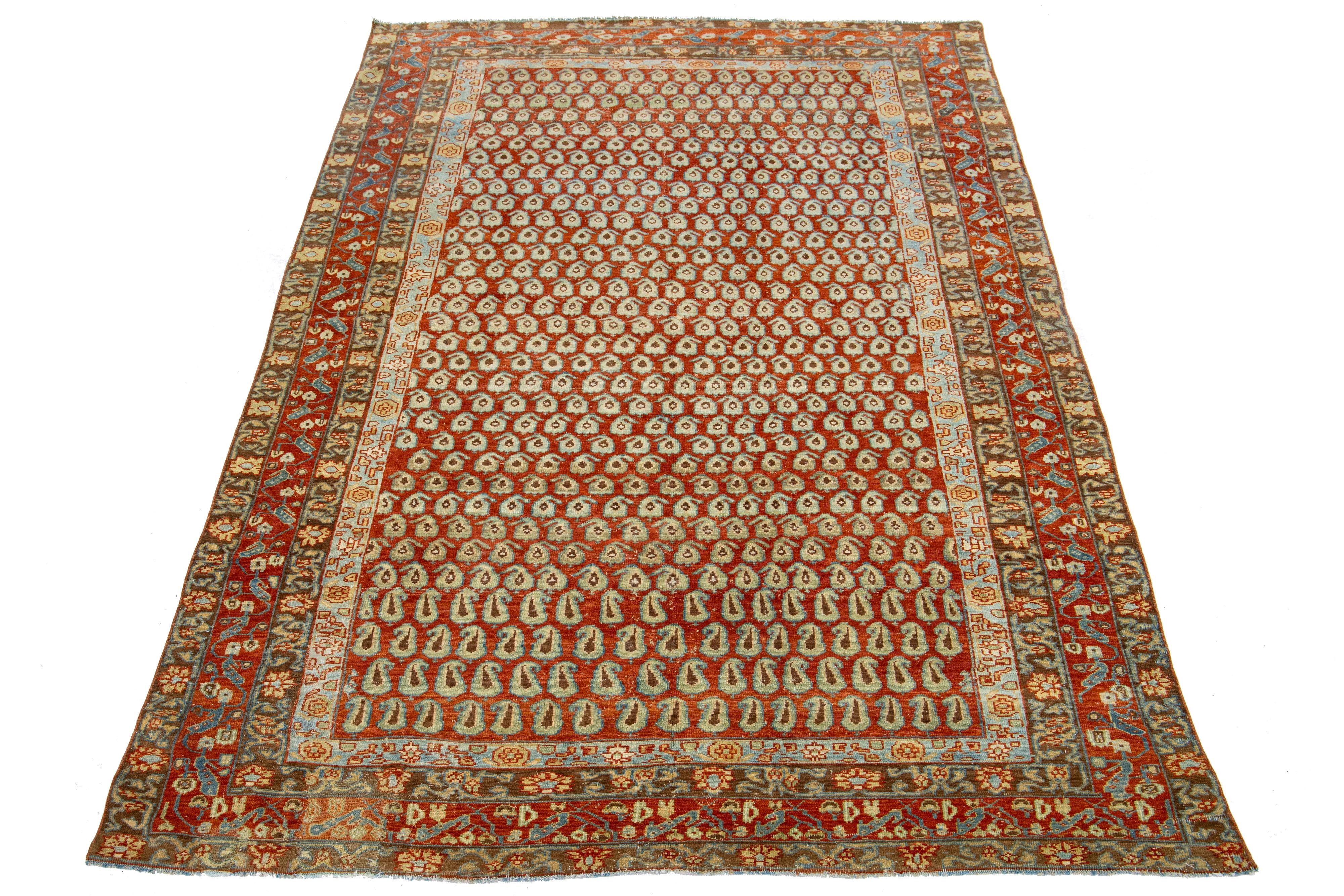 This exquisite antique Hamadan rug is hand-knotted from premium wool, boasting a red-rust field complemented by a captivating, all-over pattern design enriched with peach and blue accents.

This rug measures 6'3