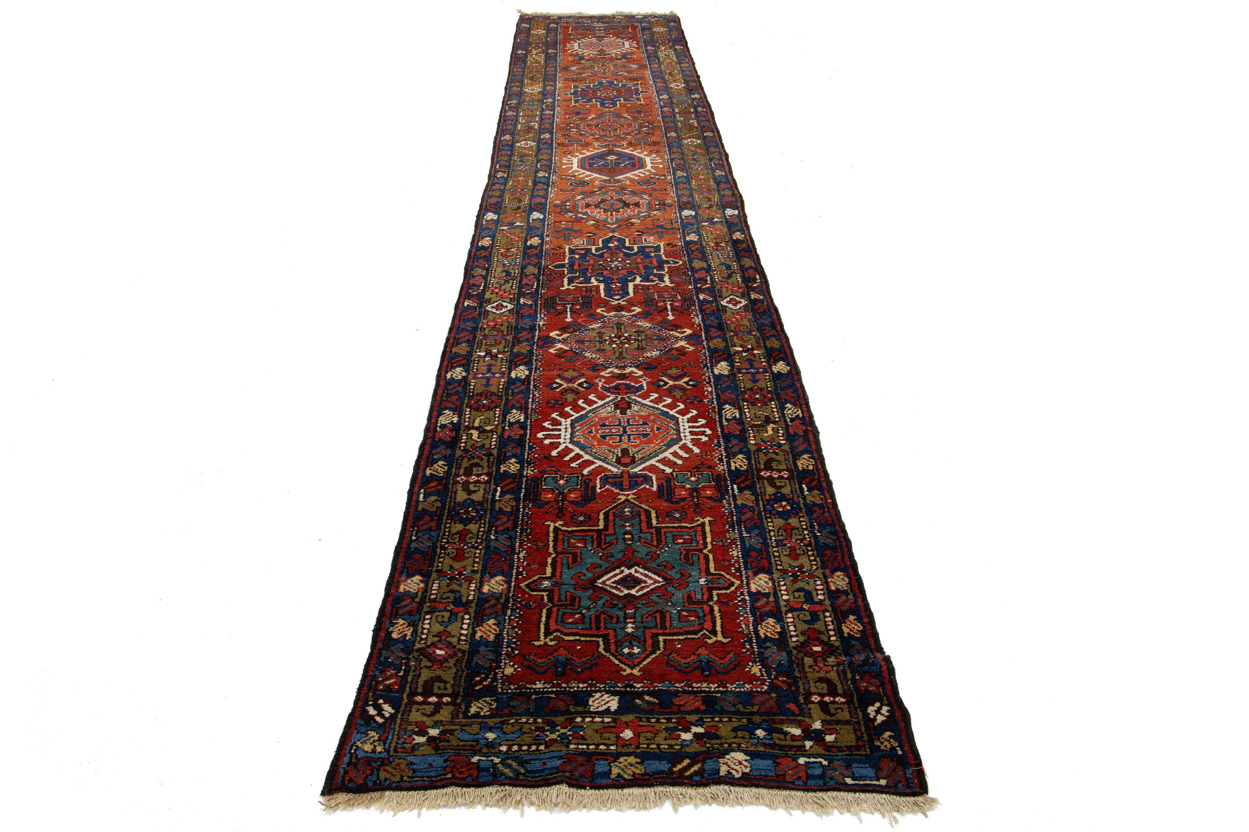 Dieser atemberaubende handgefertigte Teppich aus persischer Heriz-Wolle aus dem 20. Jahrhundert zeigt ein sattes orange-rostfarbenes Farbfeld, das mit einer harmonischen Reihe von Farben in seinem komplizierten Design wunderschön akzentuiert