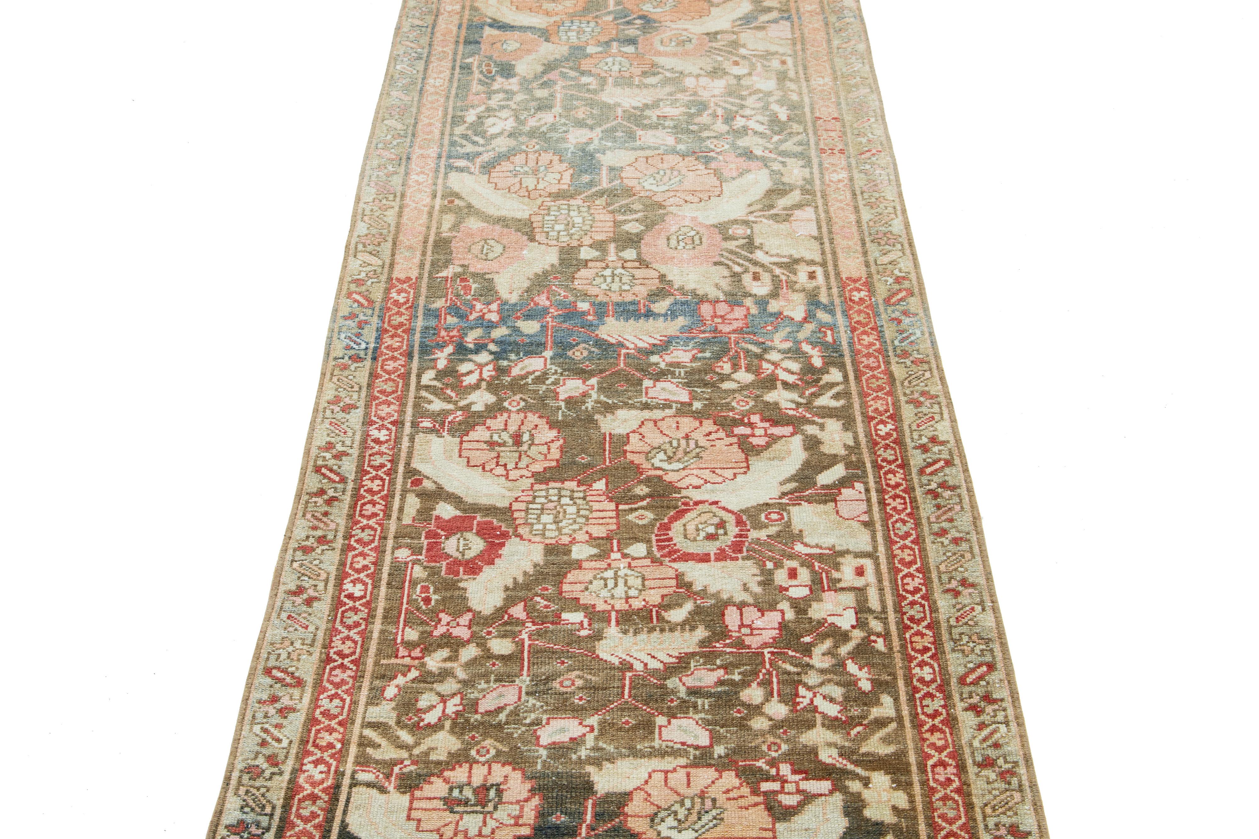 Le tapis persan en laine Heriz présente un motif floral traditionnel noué à la main. Le fond marron s'harmonise avec les motifs floraux complexes de couleur beige, bleue et pêche.

Ce tapis mesure 2'9