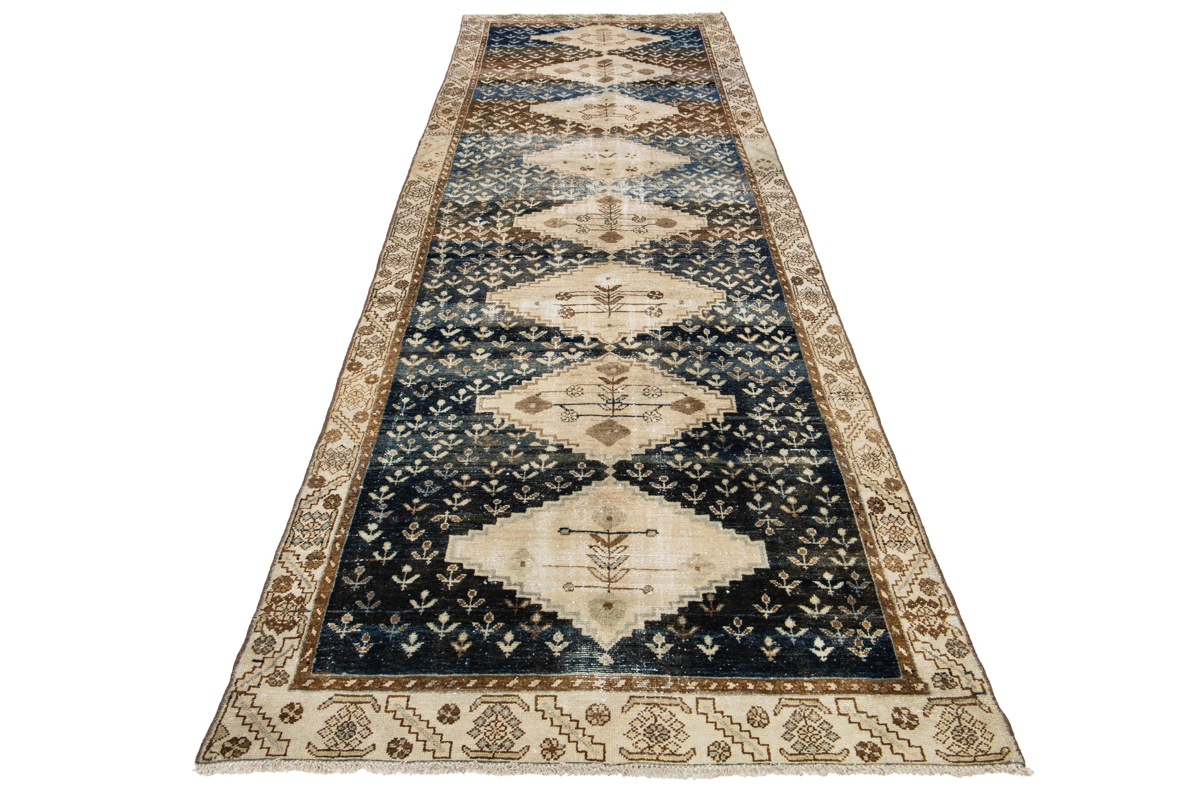 This antique Persian Malayer rug features hand-knotted wool in a navy blue and brown color field. Its allover pattern is adorned with beige accents, giving it a charming look.

This rug measures 4'4