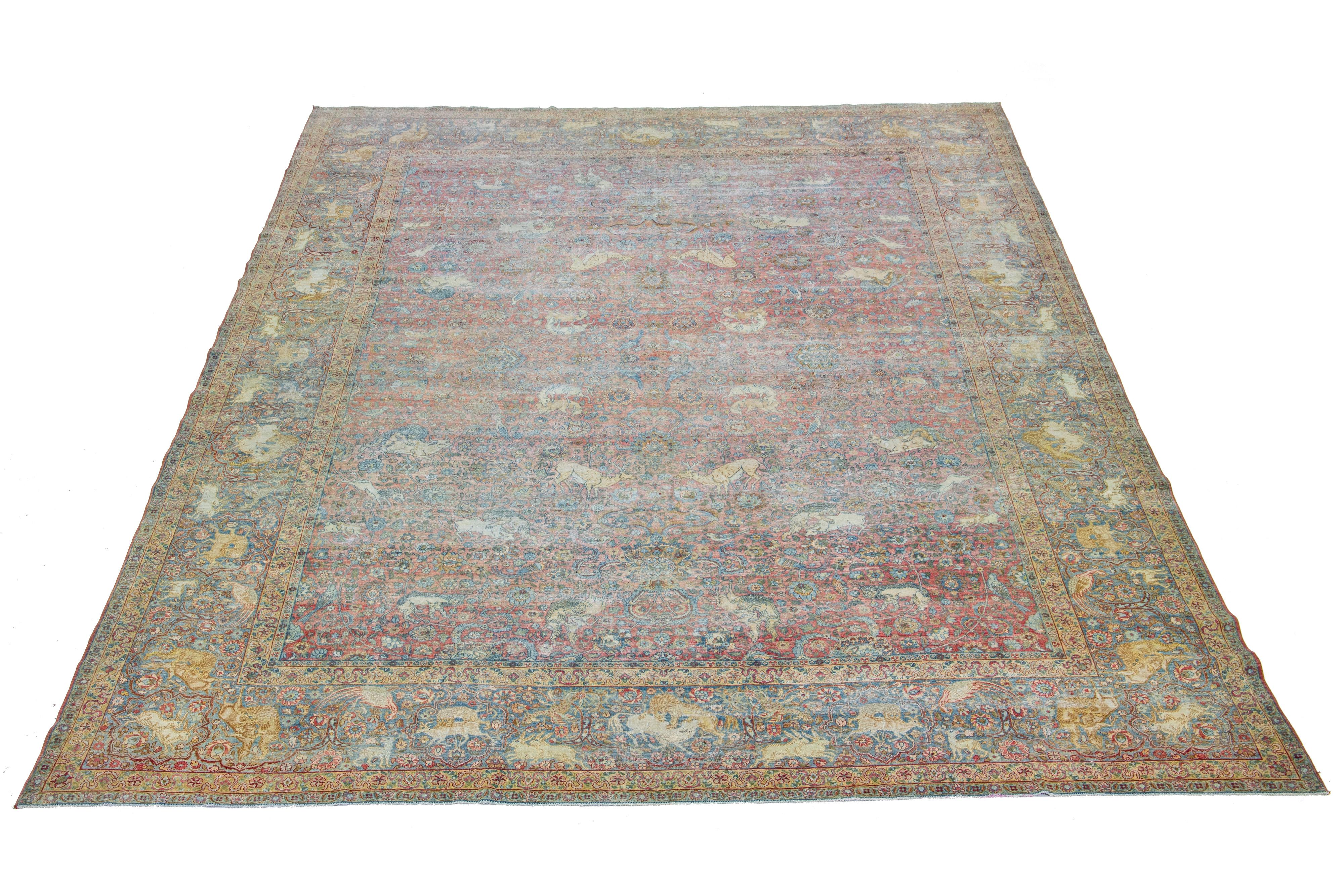 This Persian Tabriz wool rug, handcrafted, showcases a traditional floral pattern. The contrast between the red-rust backdrop emphasizes the blue floral design.

This rug measures 12'10