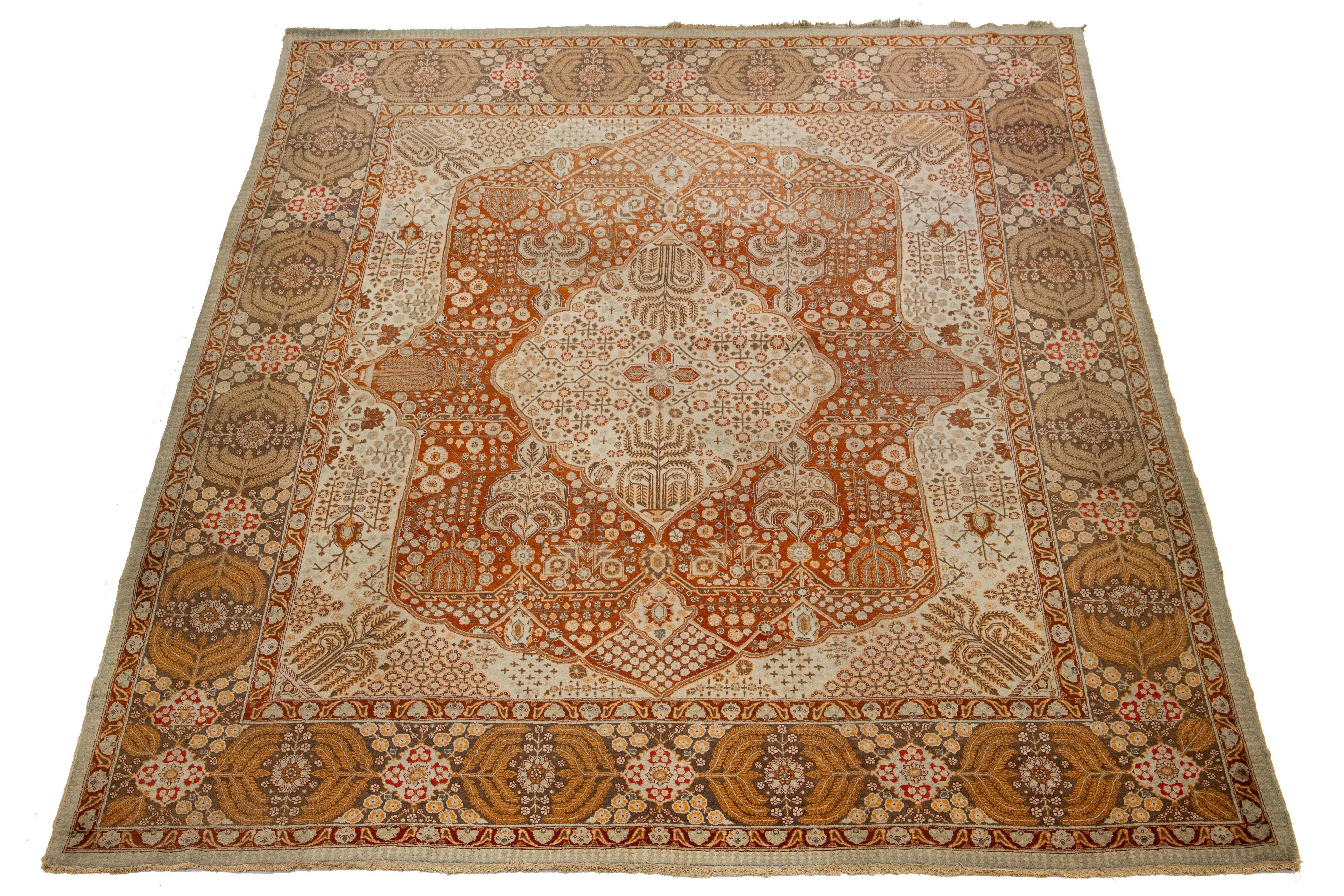 Questo tappeto in lana è un antico persiano annodato a mano con un campo arancione e accenti beige, pesca e grigi in tutto il disegno. 

Questo tappeto misura 10'9'' x 13'9''.

I nostri tappeti vengono puliti professionalmente prima della spedizione.