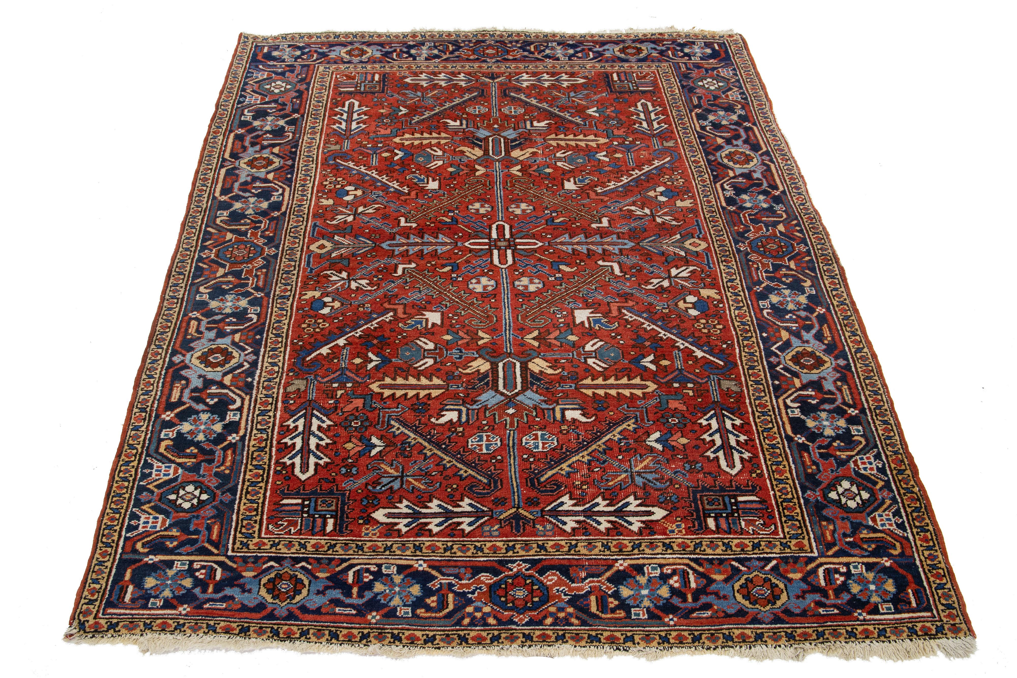 Ein antiker persischer Heriz-Wollteppich mit einem lebhaften mehrfarbigen Muster auf einem satten roten Hintergrund.

Dieser Teppich misst 6'5'' x 9'1''.

