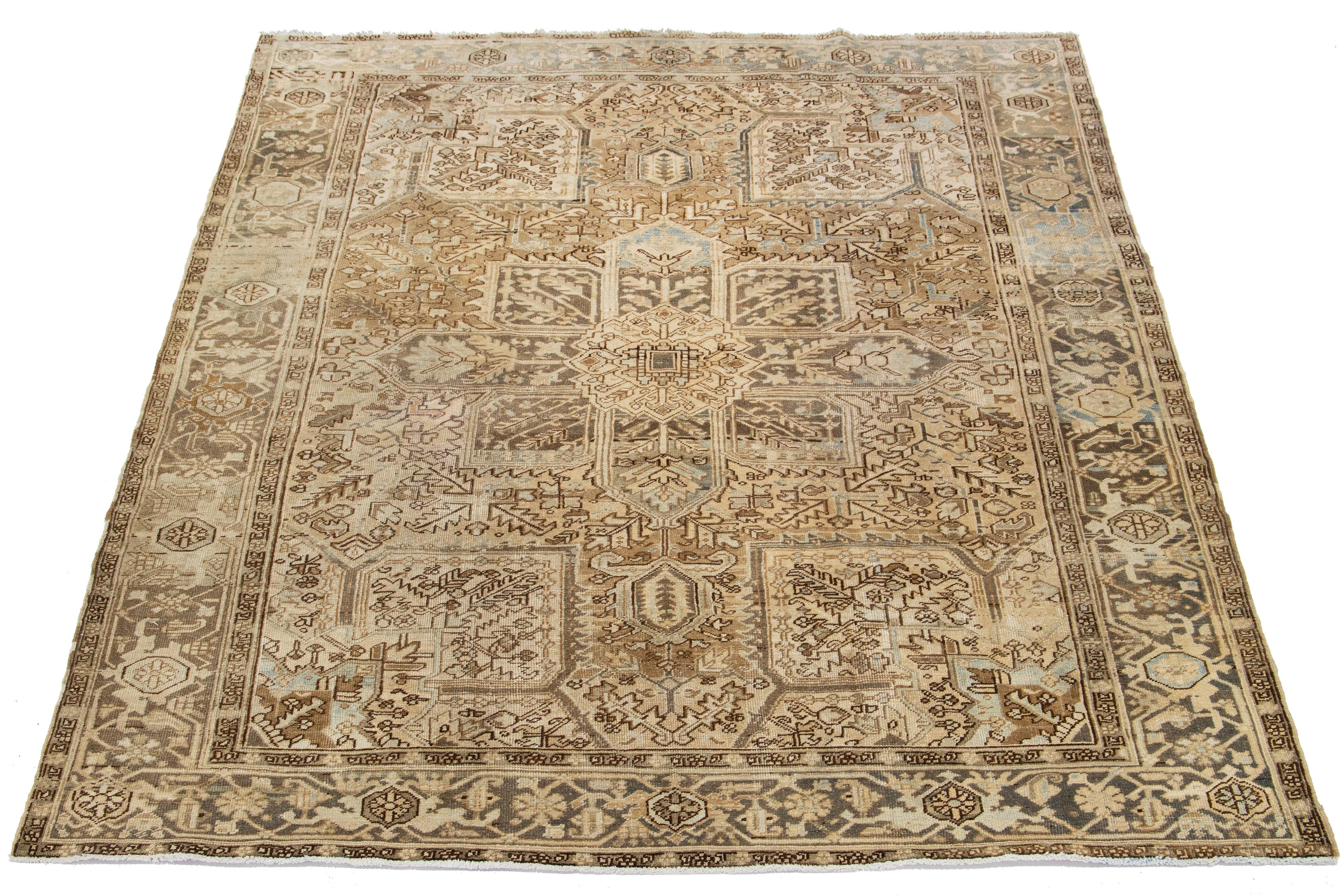 This antique Persian Heriz rug is made with hand-knotted wool. The light brown field showcases a captivating allover pattern adorned with blue, gray, and beige shades.

This rug measures 8'5' x 10'3