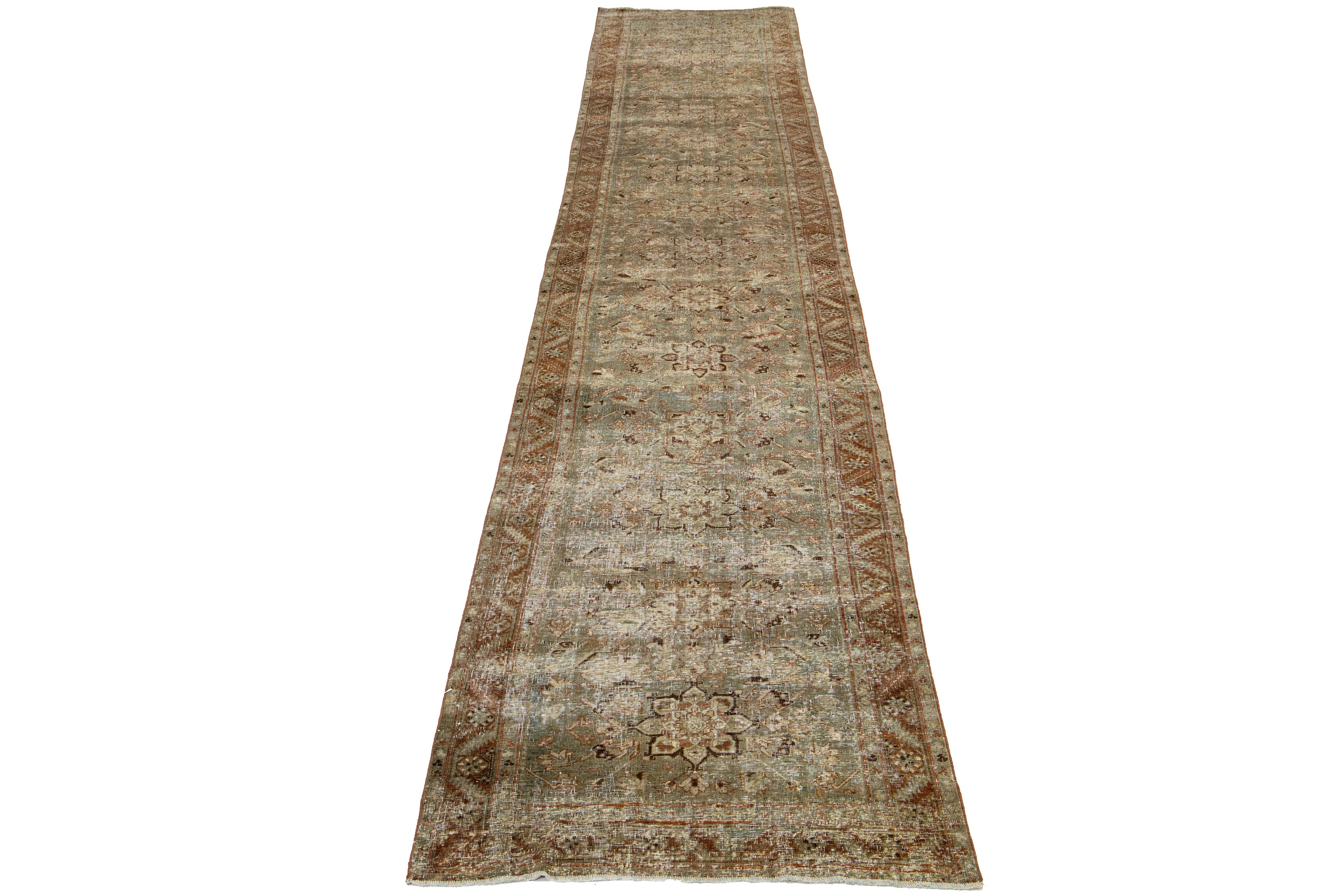 This Persian Malayer wool rug possesses an antique allure. It showcases hand-knotted wool in a blue color field. The floral pattern is embellished with rust, brown, and beige accents.

This rug measures 3' x 17'11