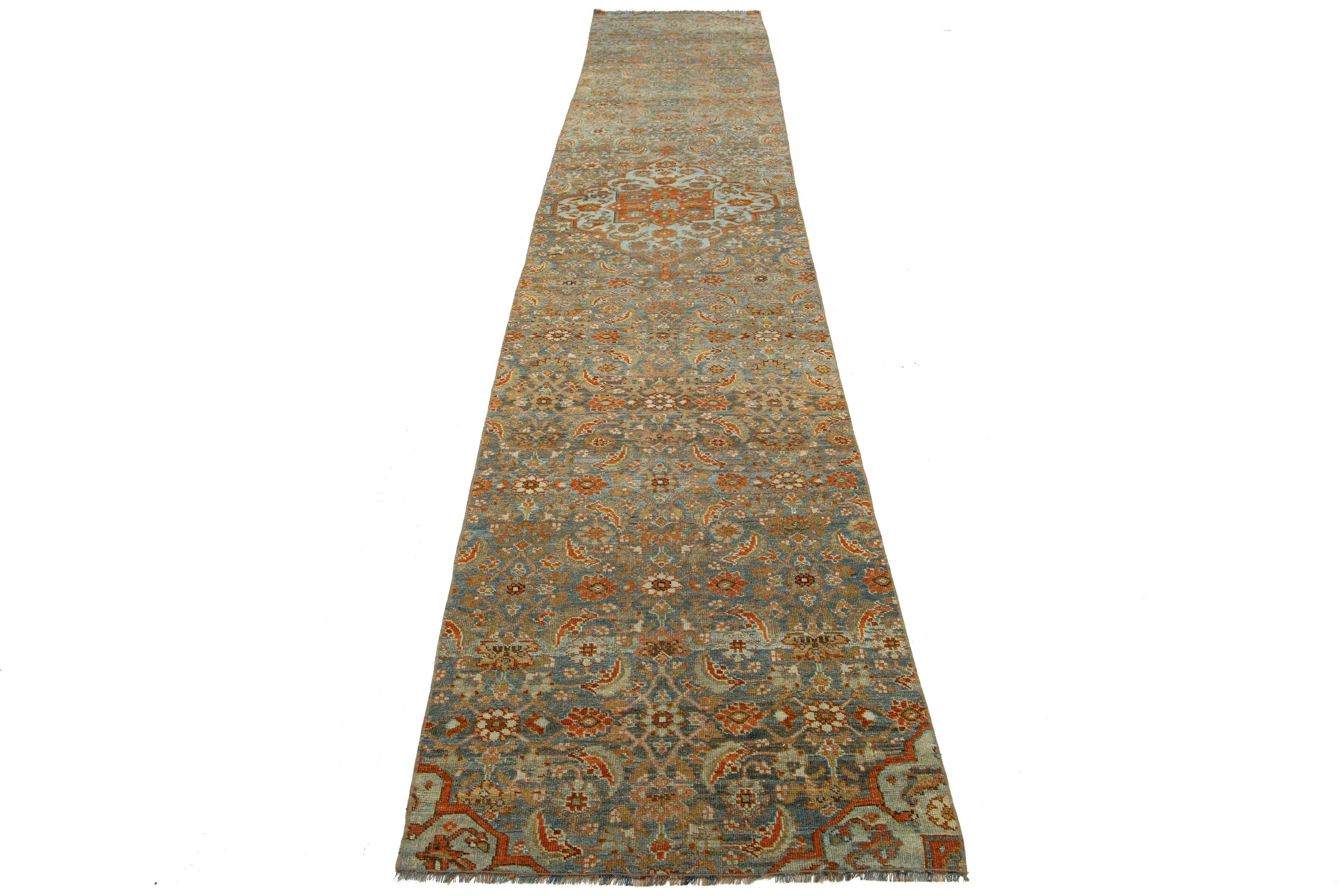 This is a 20th-century handmade Persian Malayer wool rug with a blue field and floral design accented with orange and brown.

This rug measures 2'7