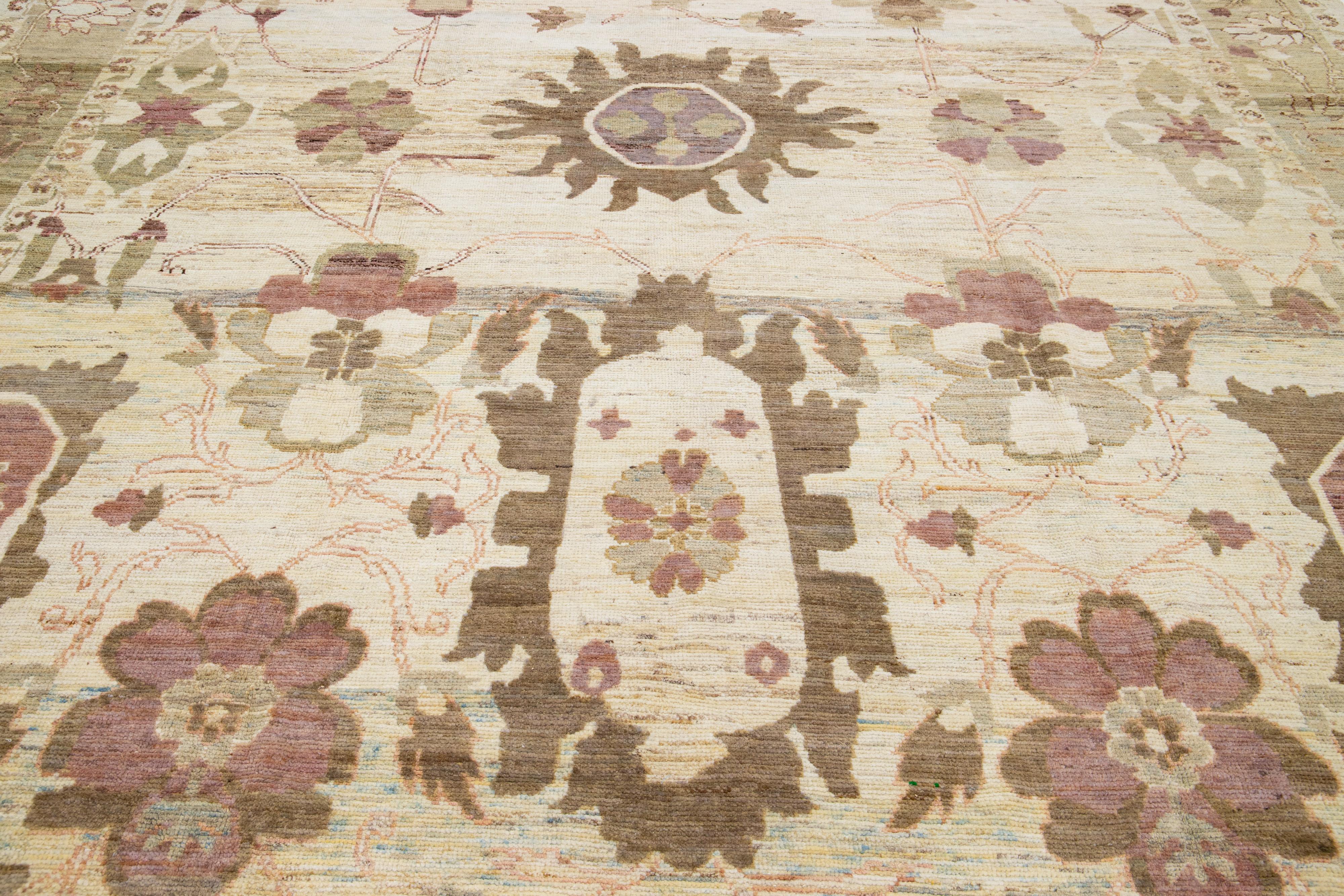 This exquisite Oushak rug, hand-knotted to perfection, boasts a contemporary style set on a beige foundation. This Persian floor-piece is framed by a green border and is beautified with multitudes of colors that culminate into an eye-catching floral