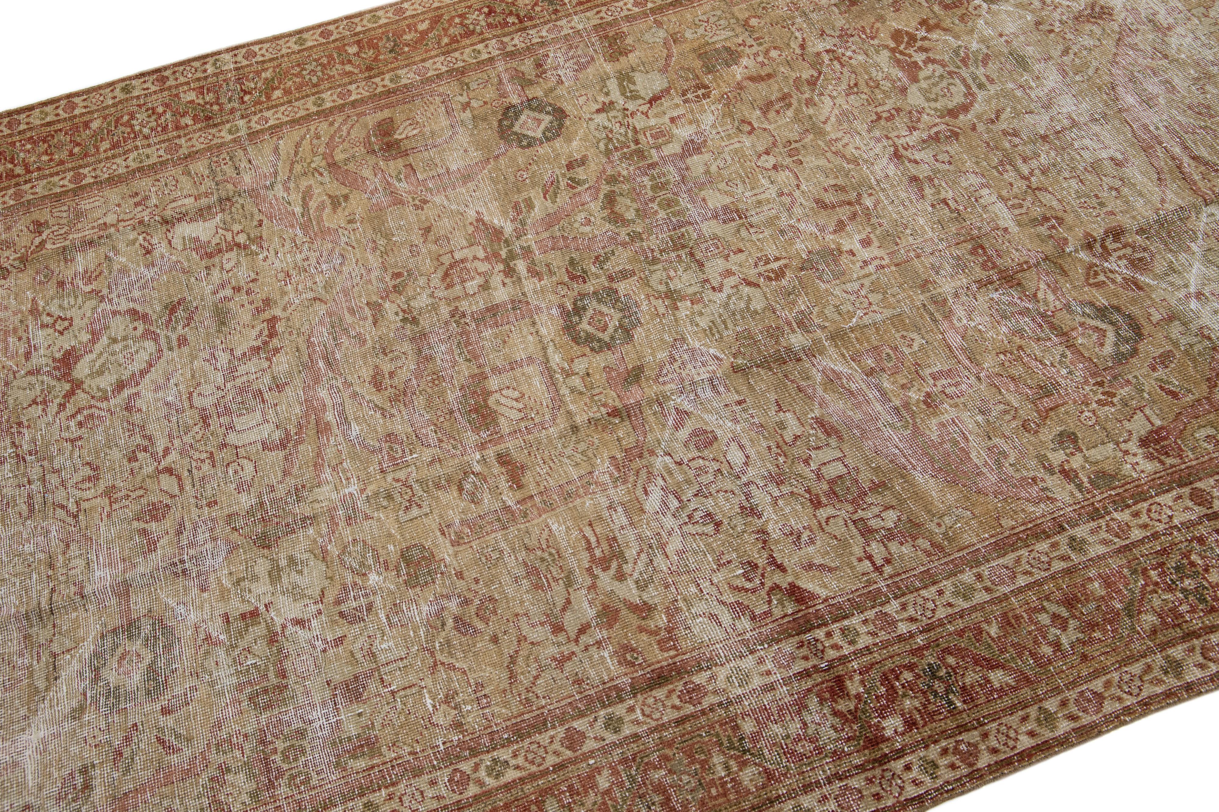 A beautiful Antique Malayer hand-knotted wool rug with a rust color field. This Persian rug has beige and green accents in an all-over floral design.

This rug measures 5'4