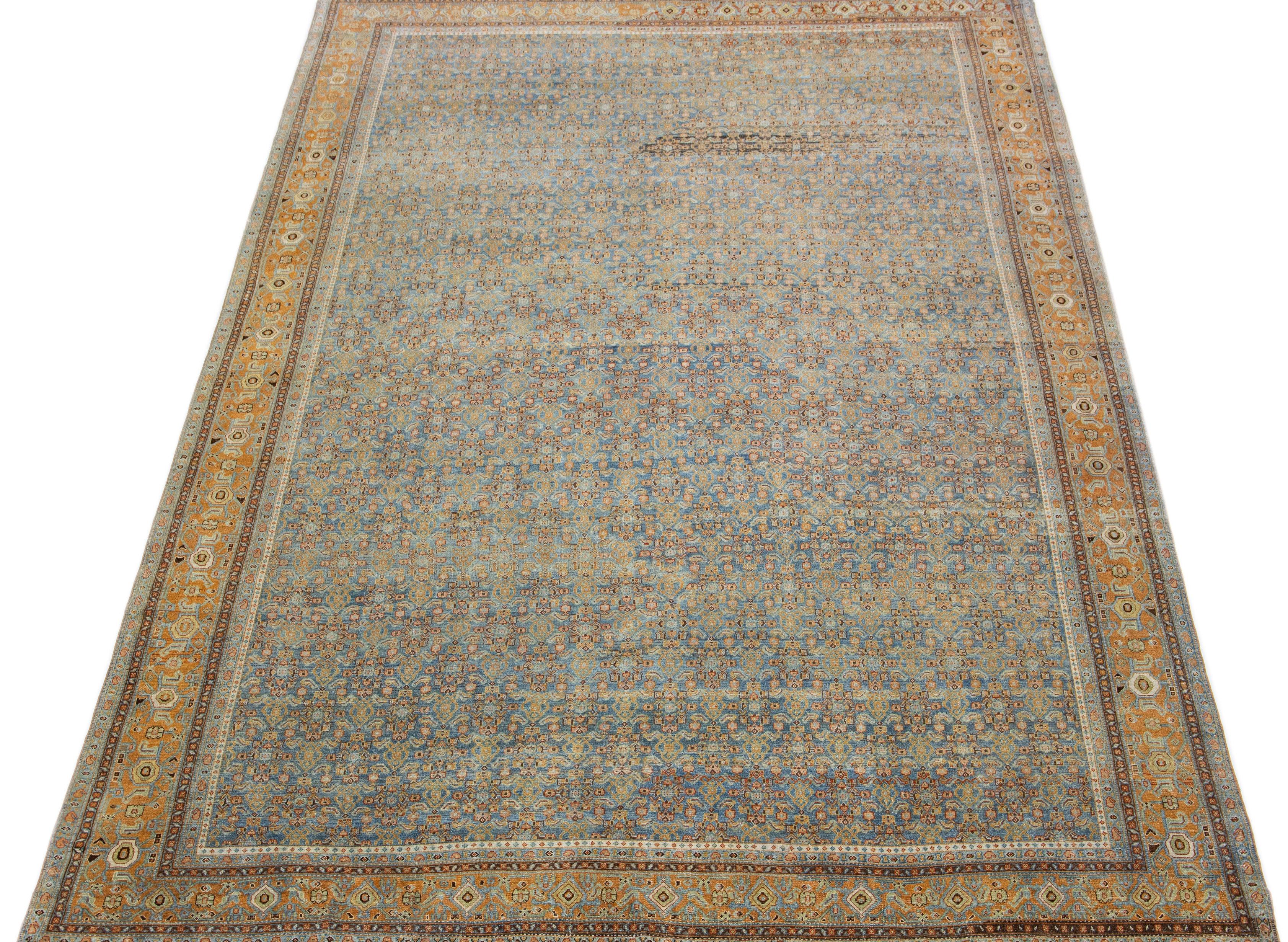 A beautiful Antique Malayer hand-knotted wool rug with a blue field. This Persian rug has beige and orange accents in an all-over floral design.

This rug measures 8'5