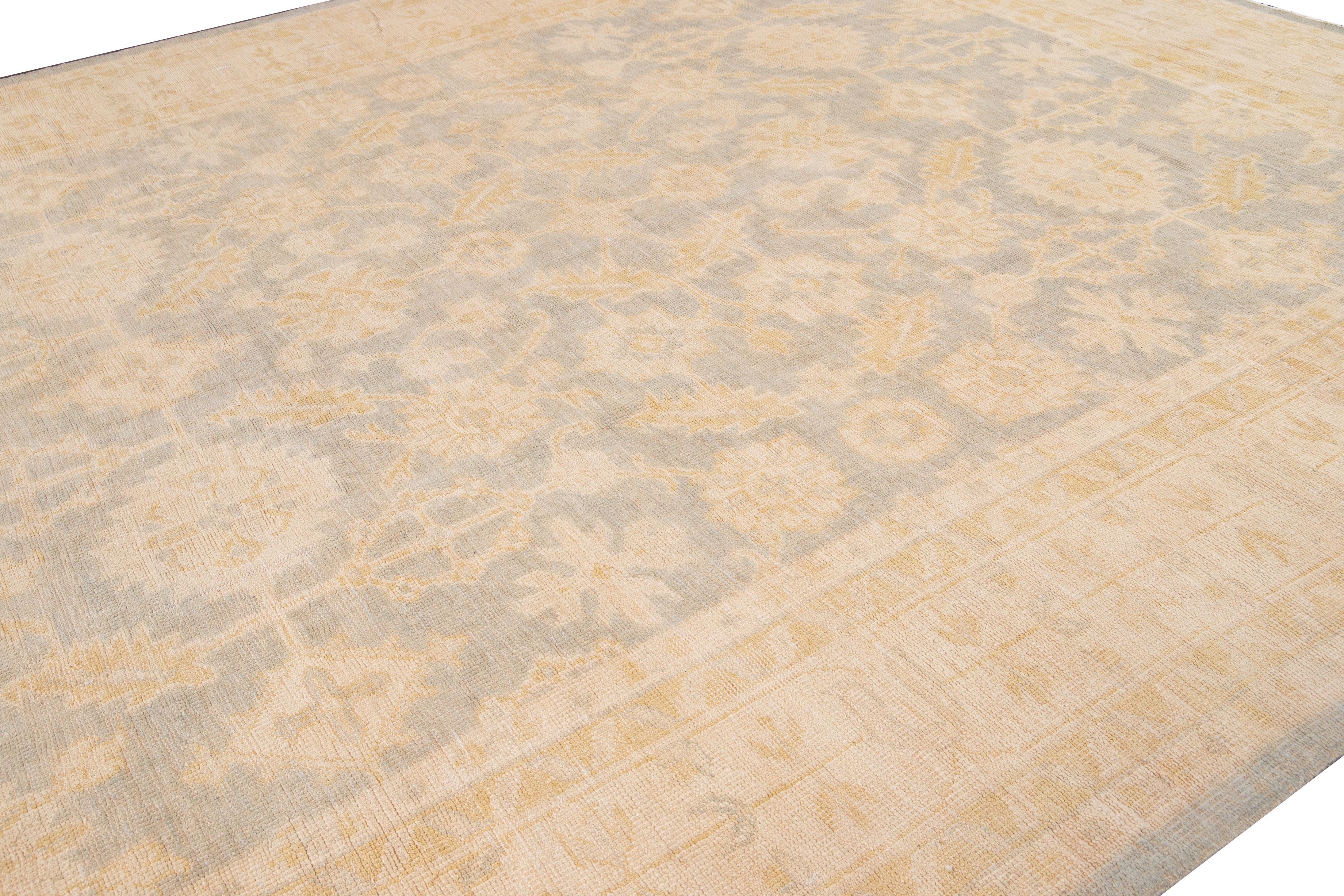 This wool rug in the Oversize Oushak Style is a stunning example of expert craftsmanship and attention to detail. Its intricate floral pattern, adorned with beige and brown accents, adds a touch of allure to any décor. The rug's base color is a