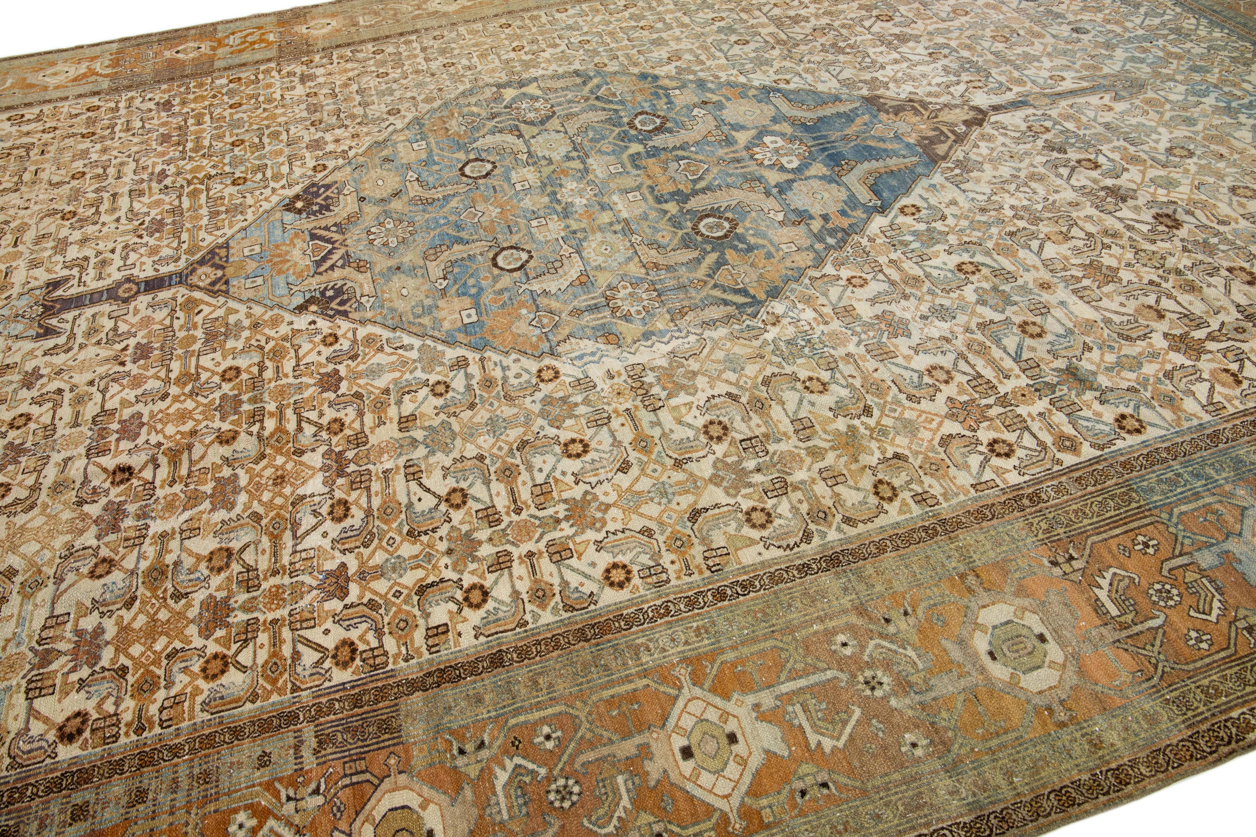 Beautiful antique Persian hand-knotted wool rug with a beige color field. This piece has a rust-designed frame with blue and brown accents in a gorgeous all-over pattern.

This rug measures: 11'6' x 17'2