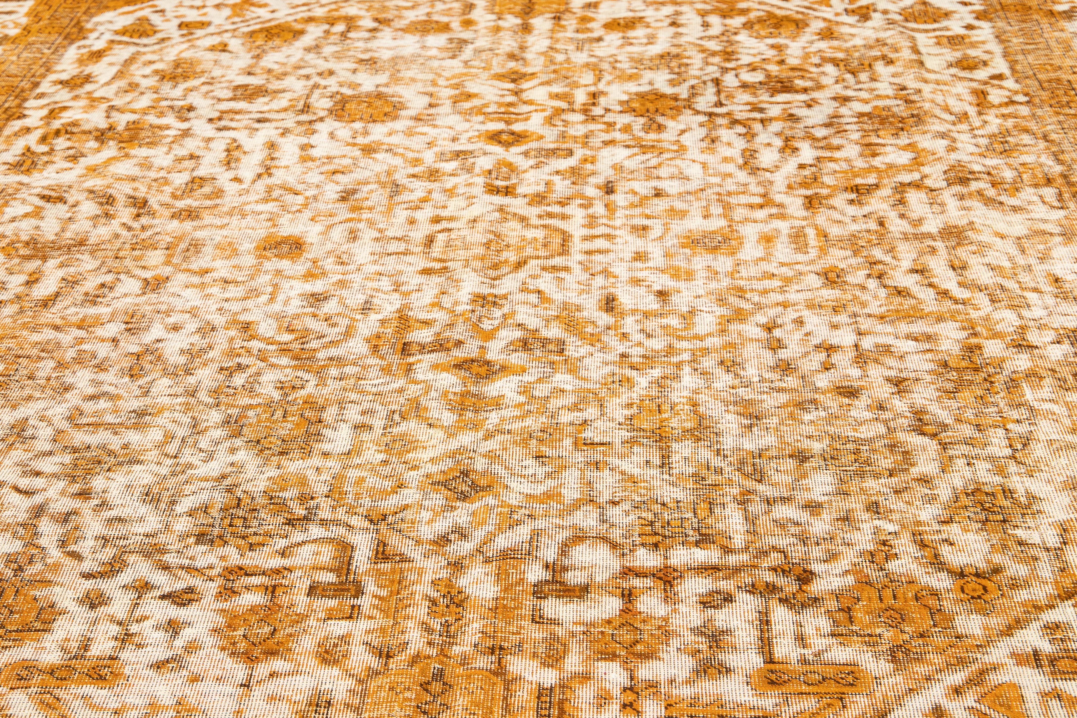 This beautiful rug with a floral design has a beige Wool field. This piece has been carefully distressed and dyed to give it a charming rustic appeal. It showcases a subdued color palette of orange and brown.

This rug measures 10' x 12'8