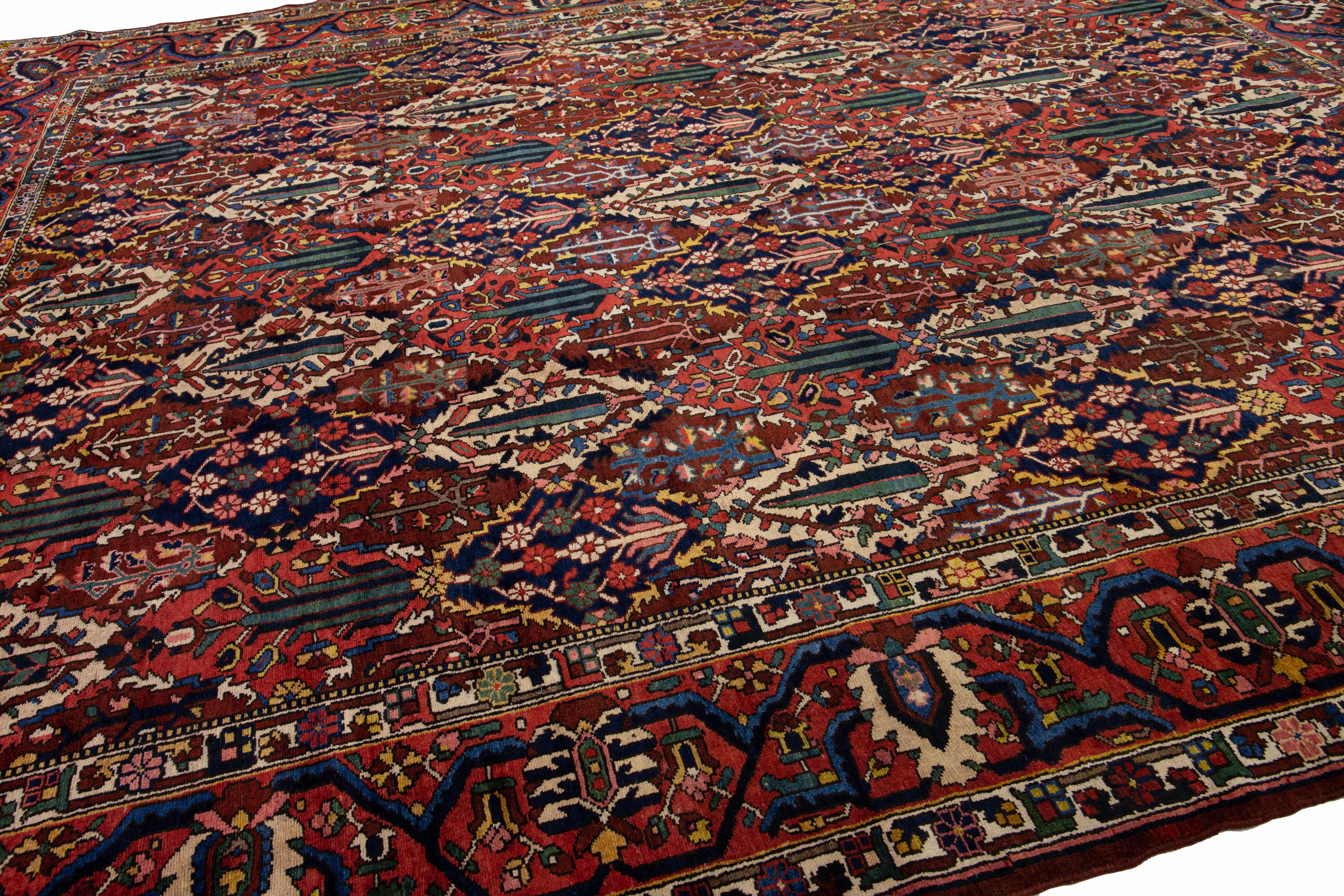 Beautiful Antique Bakhtiari hand-knotted wool rug with a red color field. This Persian piece has all-over multicolor accents in a classic pattern design.

This rug measures 12'4