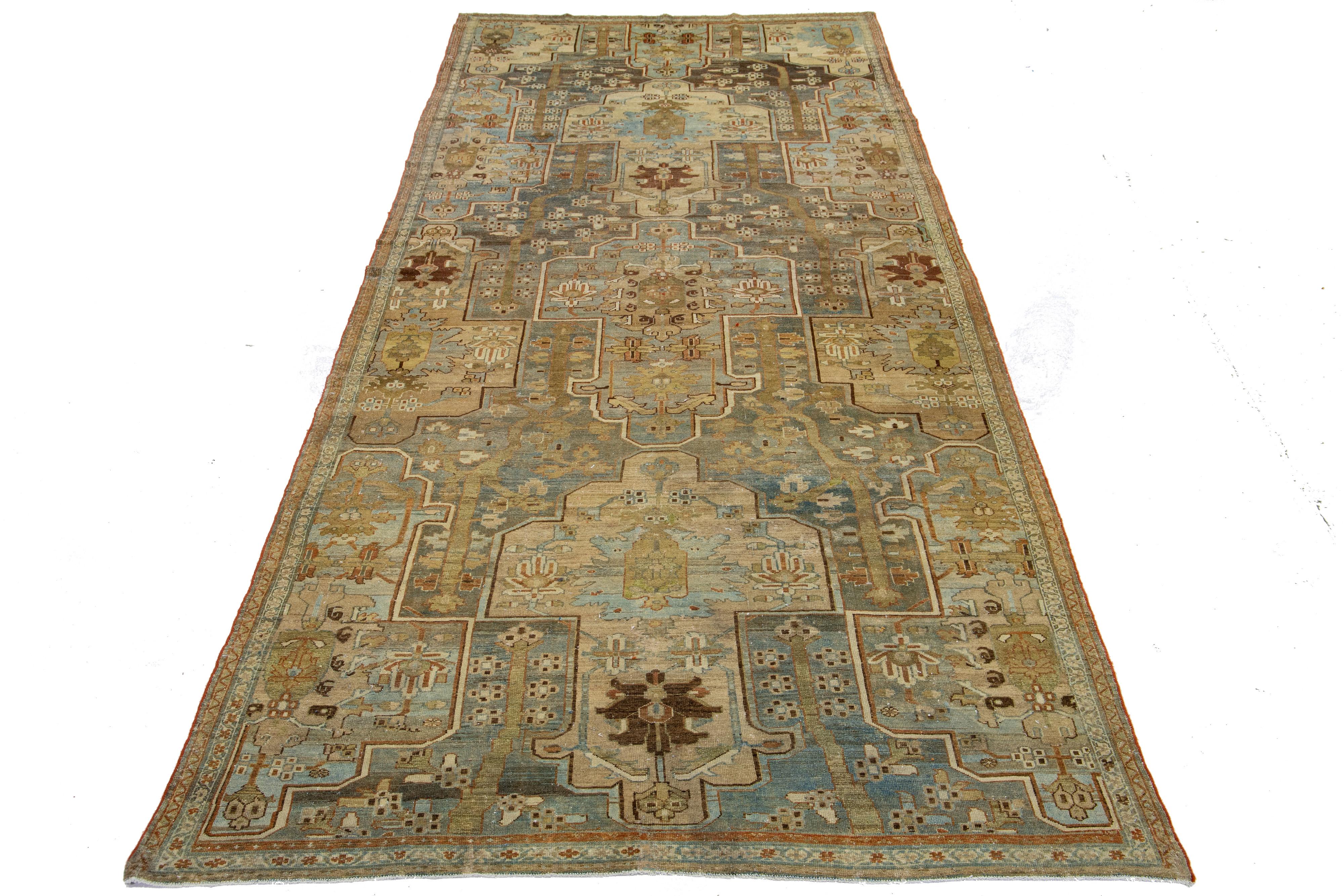 This exceptional antique Persian Malayer rug is crafted from handwoven wool. The design features a beautiful combination of blue and brown as the base, enhanced with beige and orange highlights in a stunning and intricately detailed classical floral