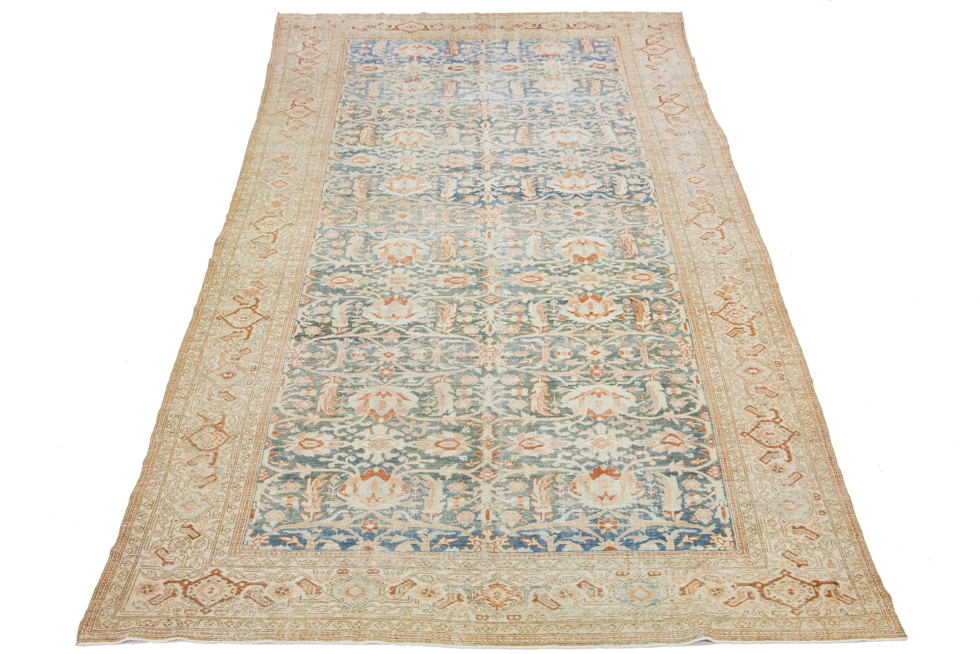 This exceptional, antique Persian Malayer rug is handcrafted from meticulously woven wool. The display features a calm light blue at its base, embellished with beige and peach highlights in an impressively intricate all-over classical floral