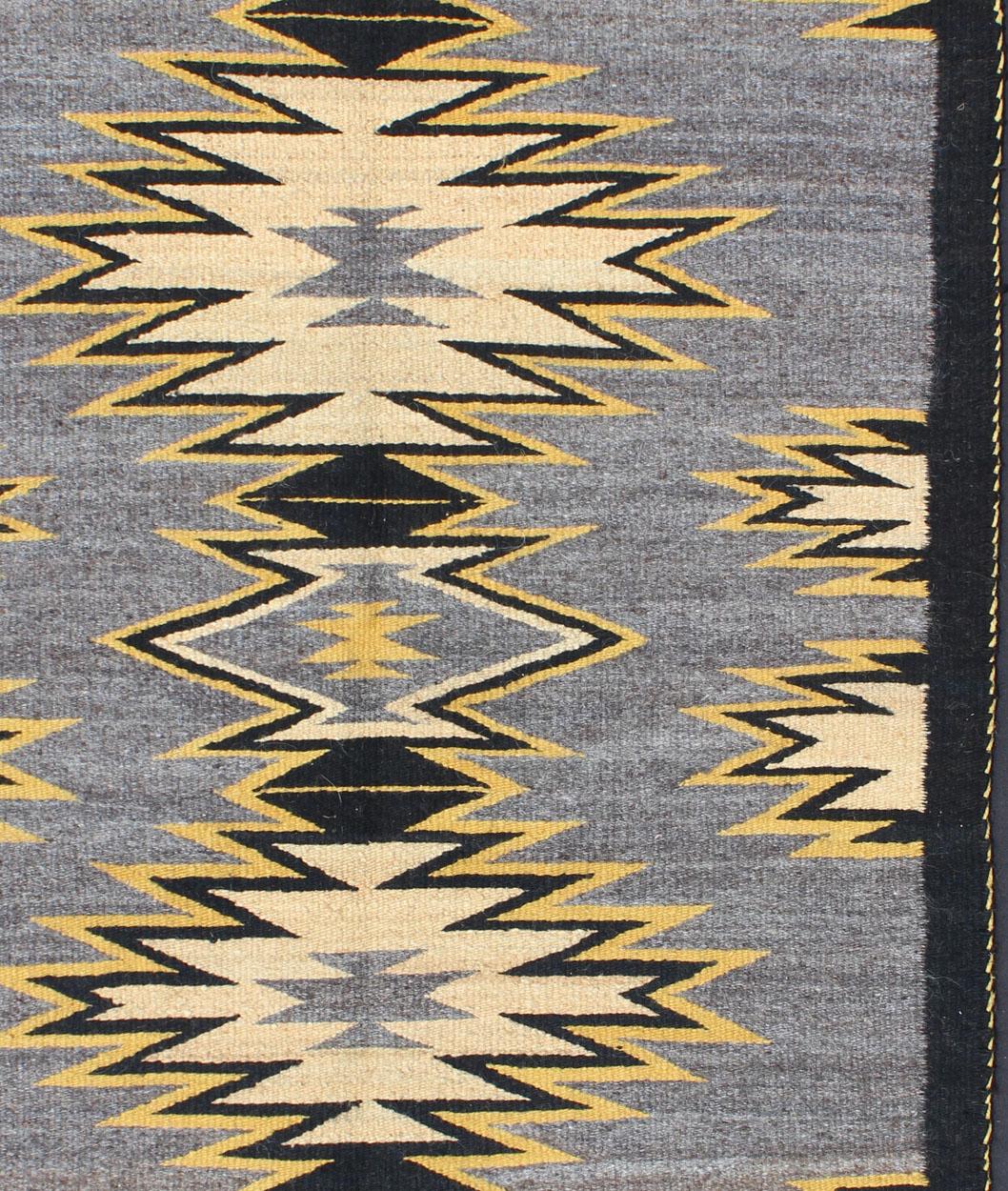 This intriguing antique Navajo Kilim, circa 1940 was woven in the United States during the first half of the 20th century. The exciting and unique composition boasts a captivating geometric composition with an all-over medallion design. The range of