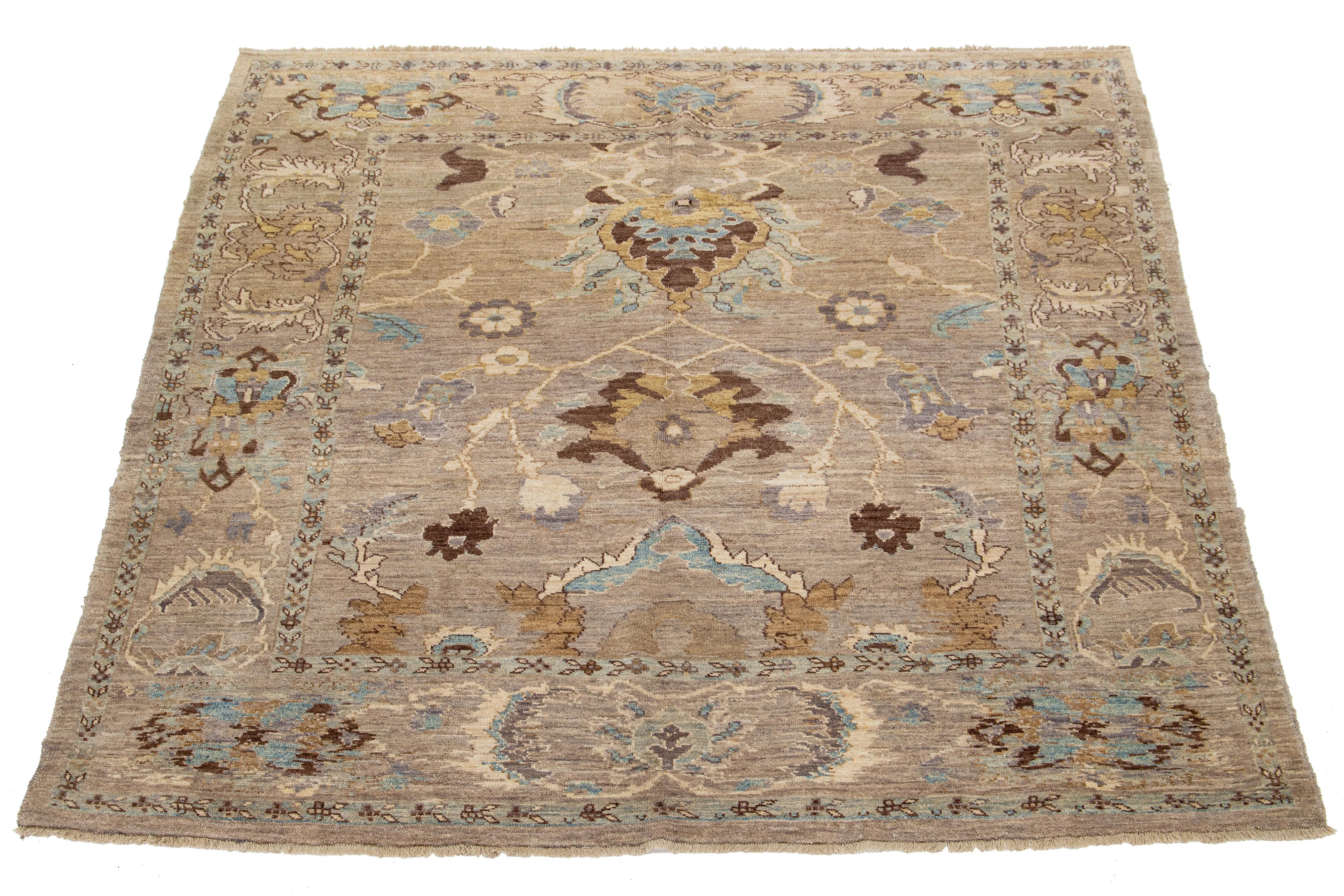 This is a Persian wool rug, hand-knotted and featuring a lovely design in blue, beige, and brown on a light brown field.

This rug measures at 8'1