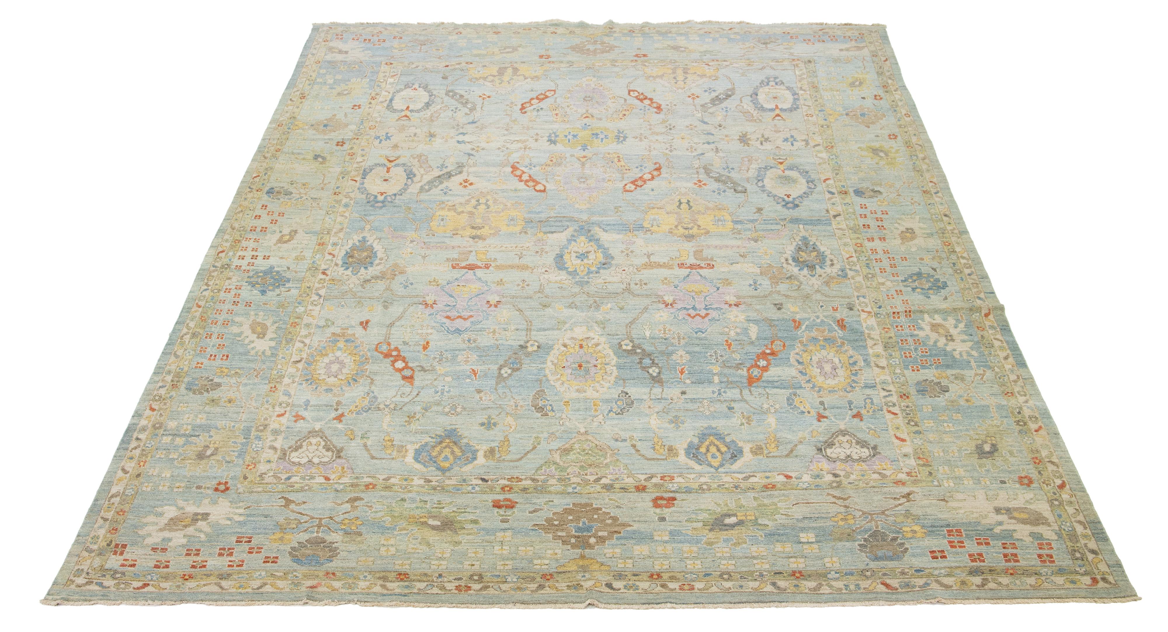Dieser handgeknüpfte Wollteppich hat einen hellblauen Hintergrund, der mit mehrfarbigen Akzenten in einem Allover-Muster verziert ist.

Dieser Teppich misst 13'2'' x 16'11''.