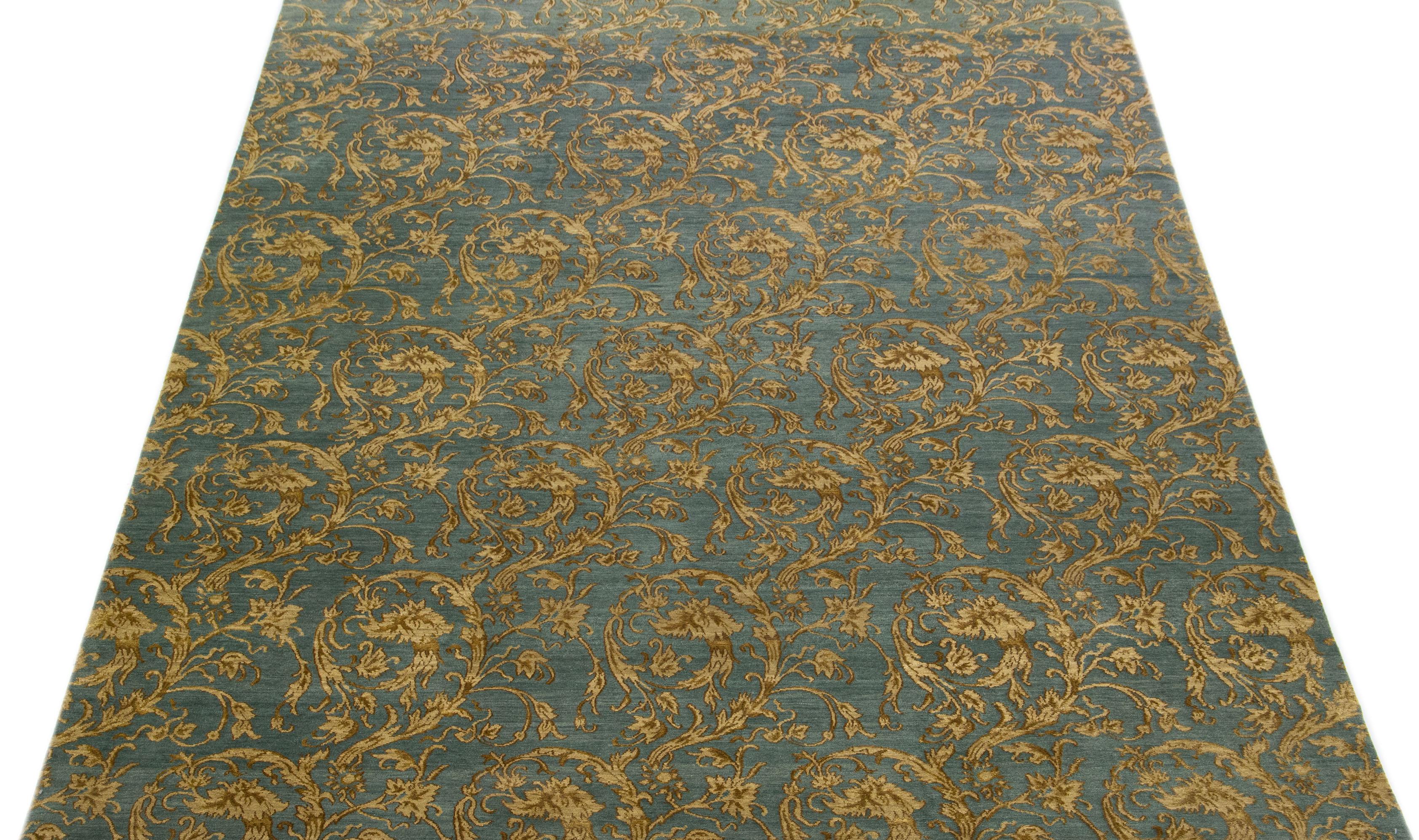 Beautiful modern Tibetan hand knotted wool and silk rug with a blue color field. This Tibetan rug has golden accents in a gorgeously damask pattern design.

This rug measures 8'8