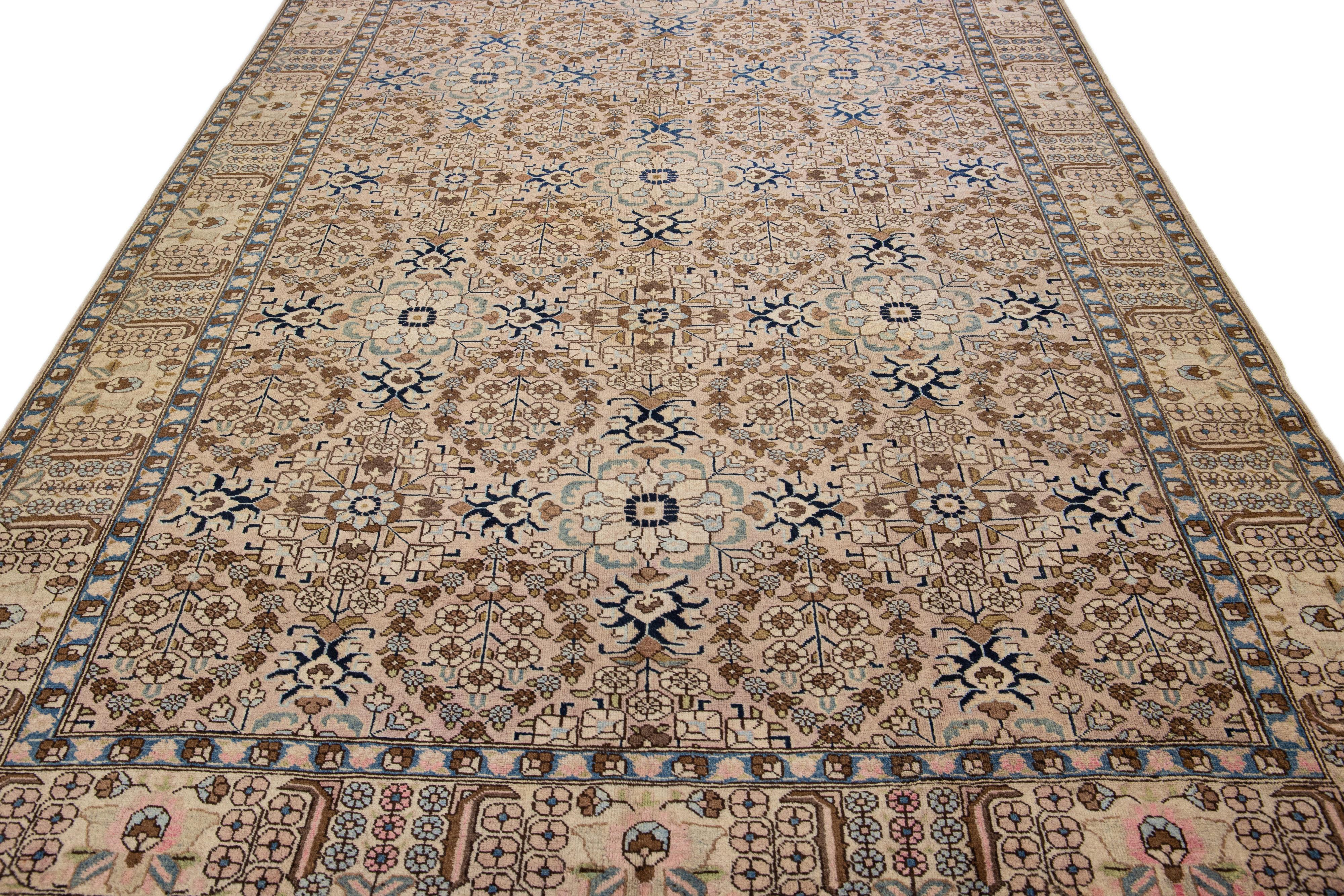 Beautiful antique Tabriz hand-knotted wool rug with a peach field. This Persian piece has blue, brown, and beige accents in a gorgeous all-over floral design.

This rug measures 7' x 10'5