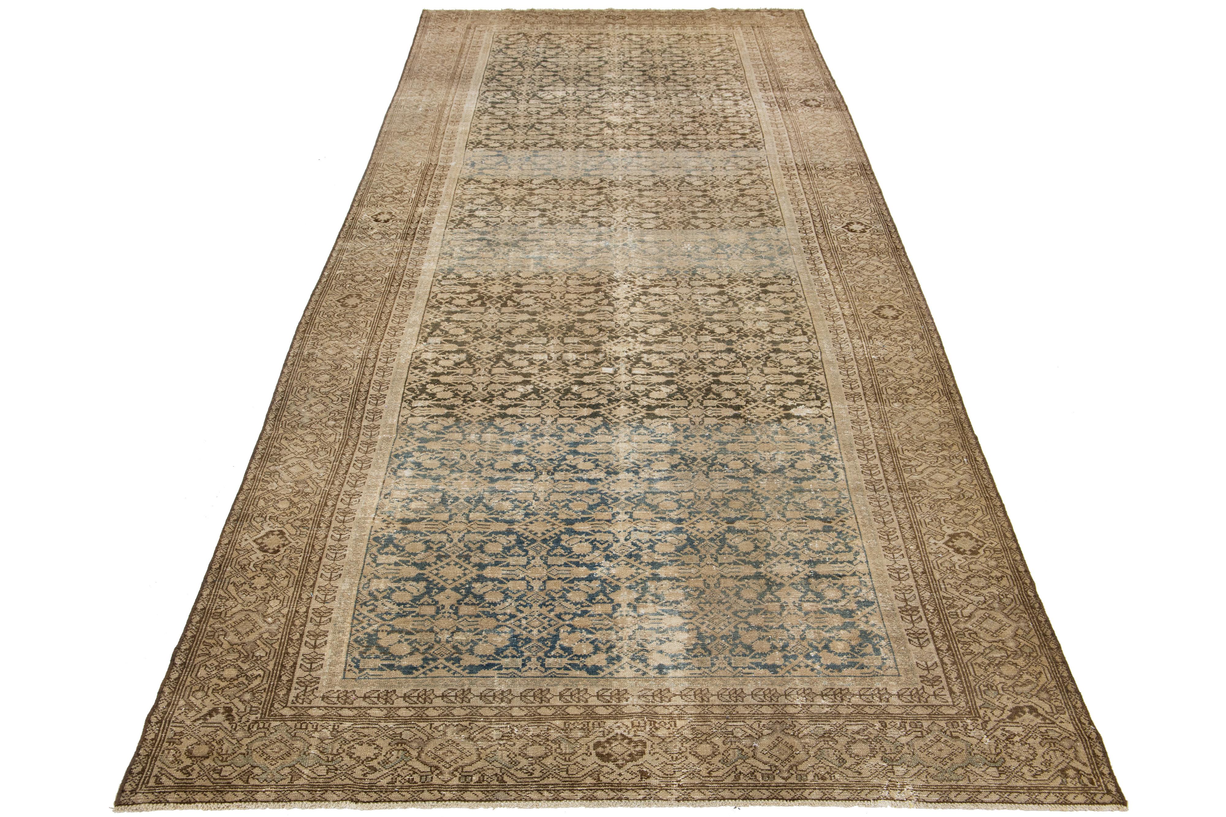 Dieser außergewöhnliche antike persische Malayer-Teppich ist aus handgeknüpfter Wolle gefertigt. Das Design zeichnet sich durch eine schöne Kombination aus Beige und Braun als Basis aus, die durch blaue Akzente in einem atemberaubenden und