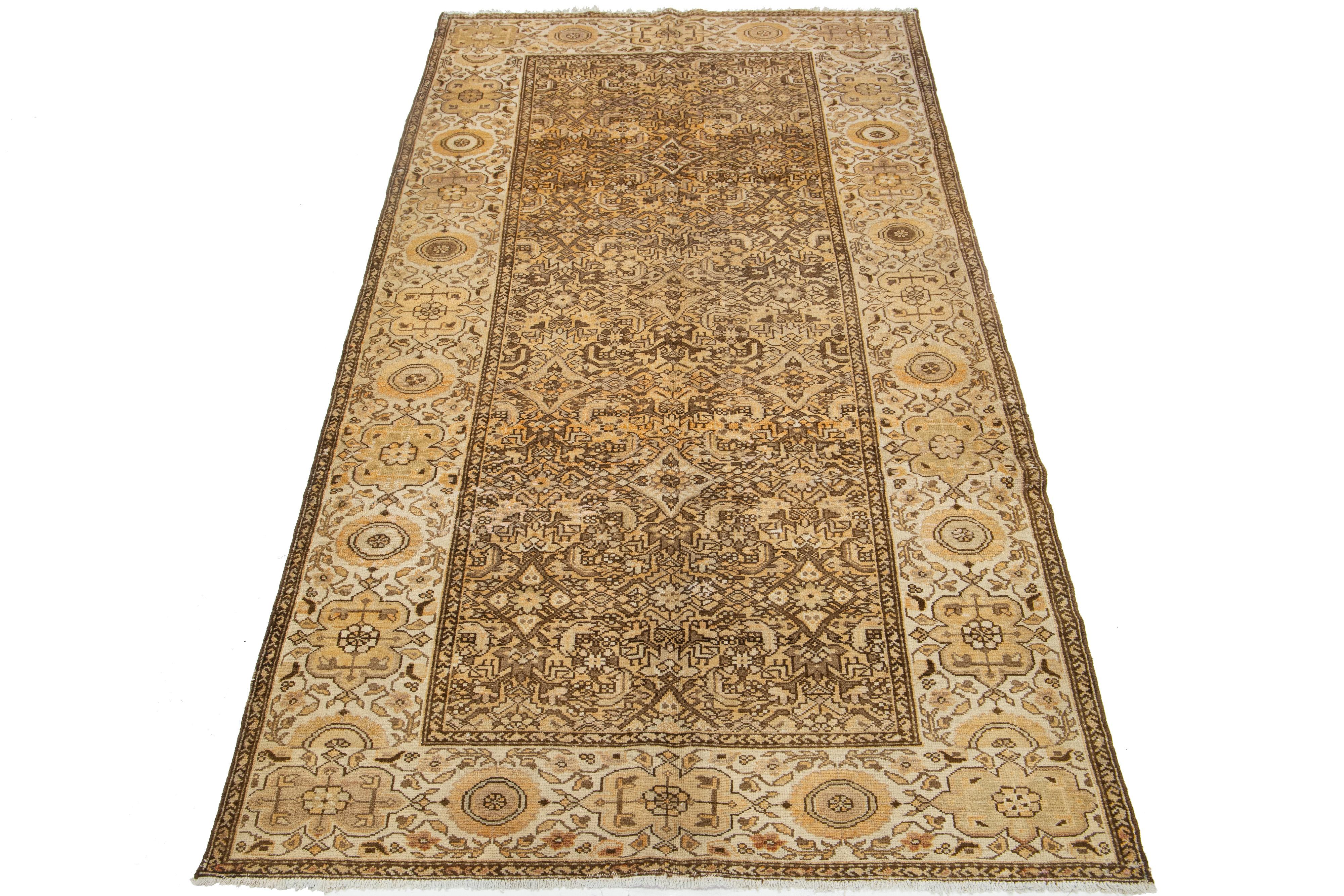 This antique Persian Malayer rug is hand-knotted wool. The design features a beautiful combination of beige and orange as the base, enhanced with brown highlights in a stunning, detailed floral pattern.

This rug measures 4'11