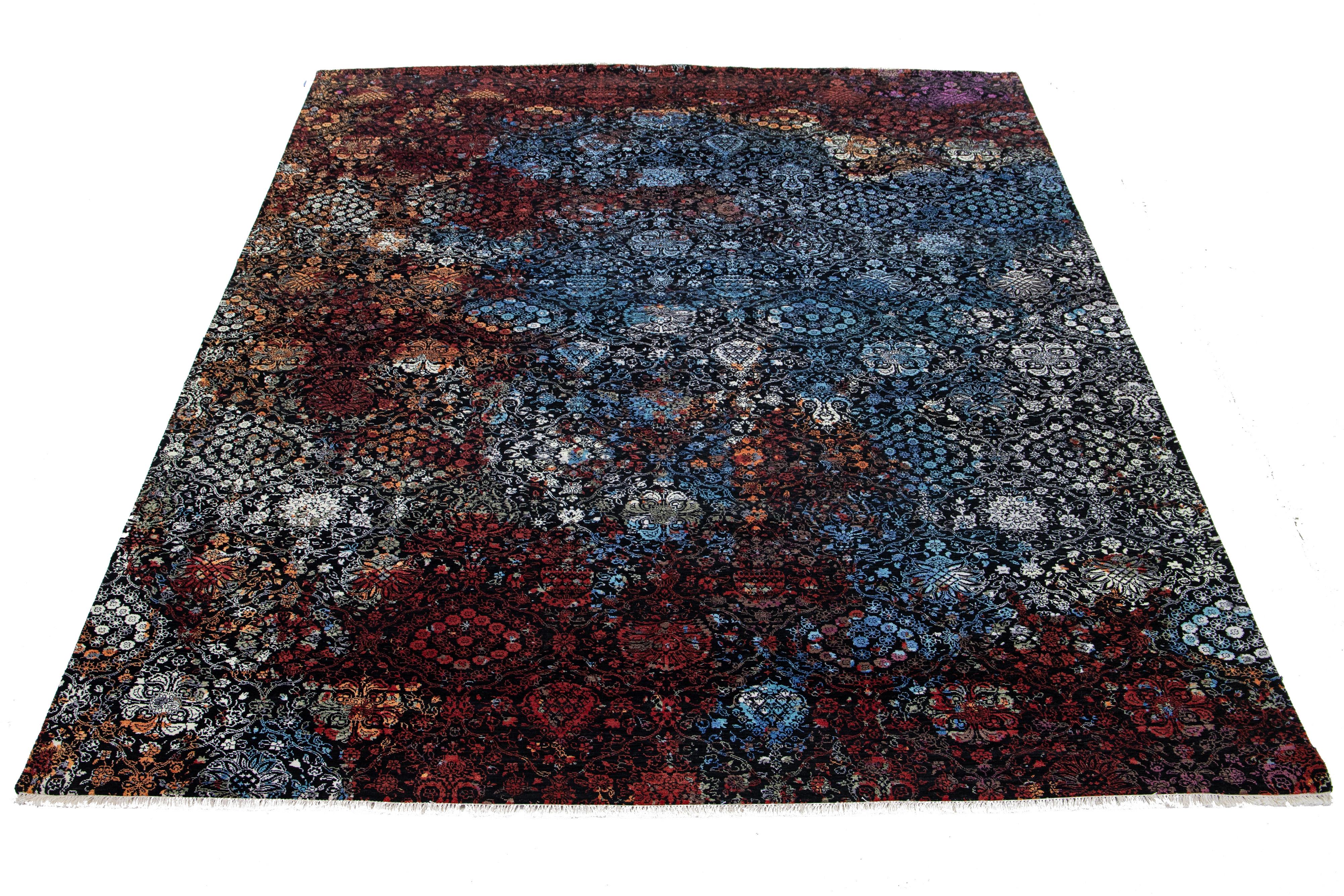This hand-knotted wool rug showcases a black field. It's designed with a stunning floral pattern and accented with white, red, orange, and blue hues in a Transitional allure.

This rug measures 10'2