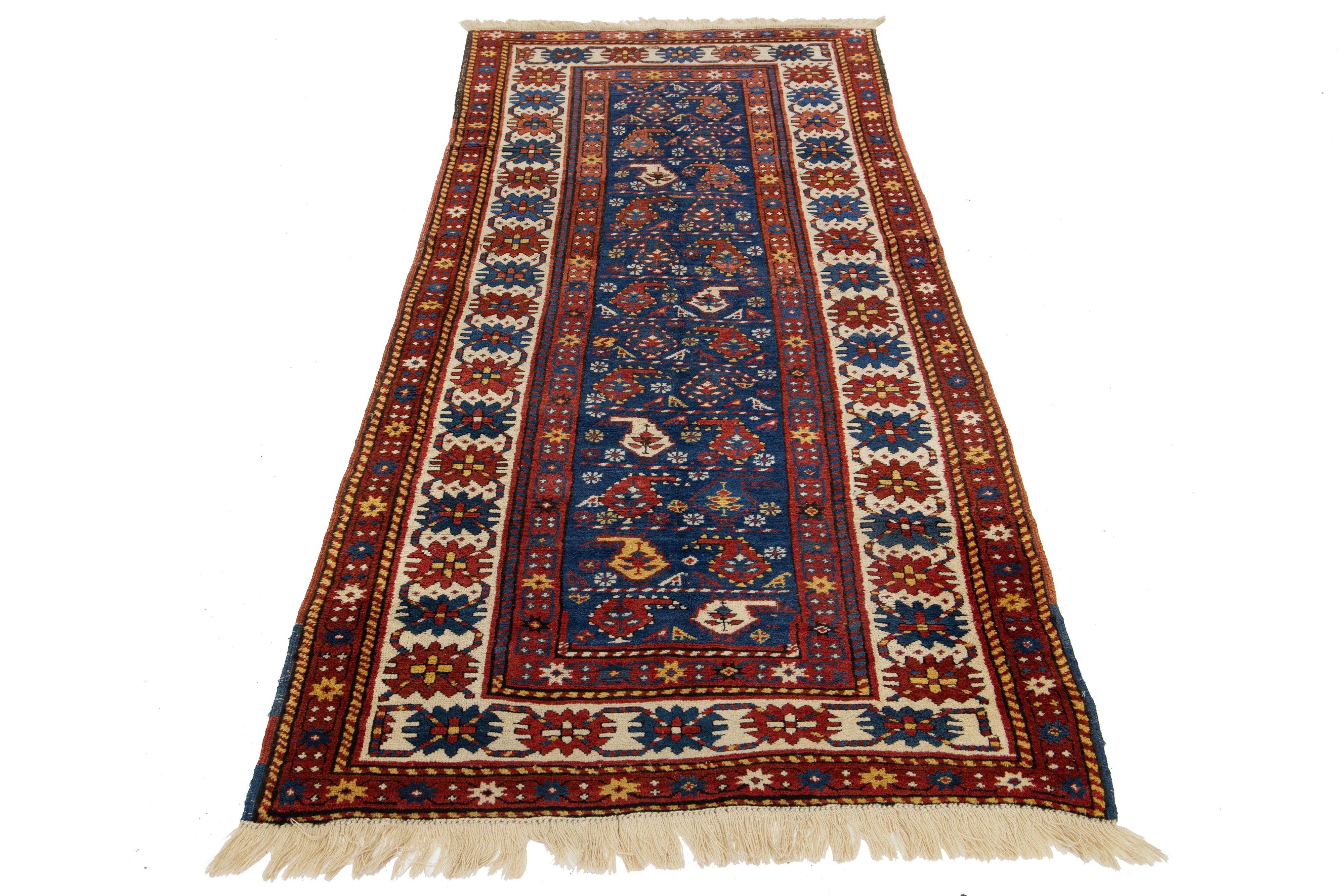 Dieser handgefertigte Teppich aus Kazak-Wolle besticht durch seine leuchtende blaue Farbpalette mit zarten roten, gelben und beigen Akzenten. Es ist mit einem komplizierten Allover-Muster verziert.

Dieser Teppich misst 3'6'' x 7'10''.