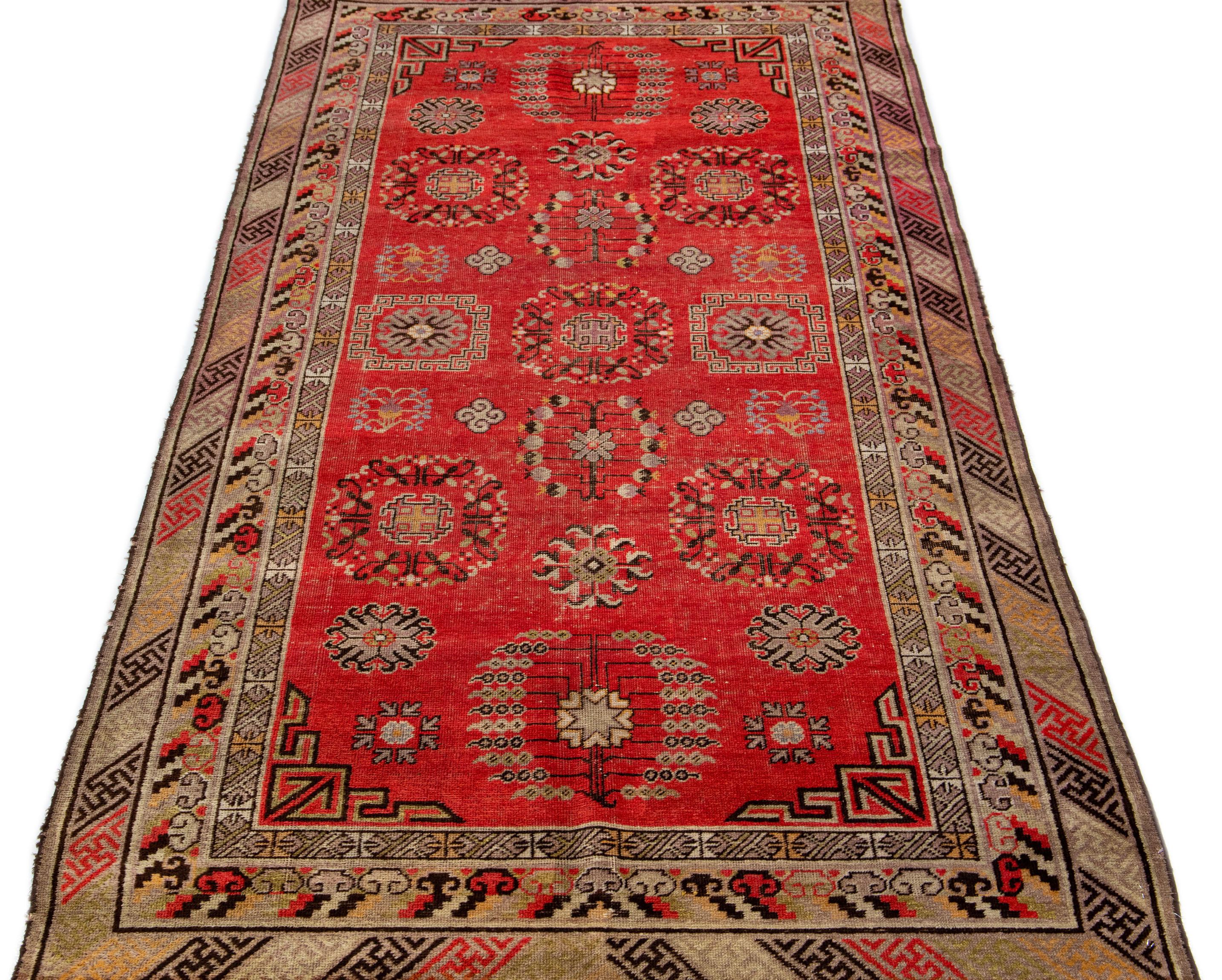 Beautiful vintage Khotan Hand-knotted wool rug with a red field. This Khotan rug has multicolor accents in a gorgeous all-over tribal design.

This runner measures 4'3