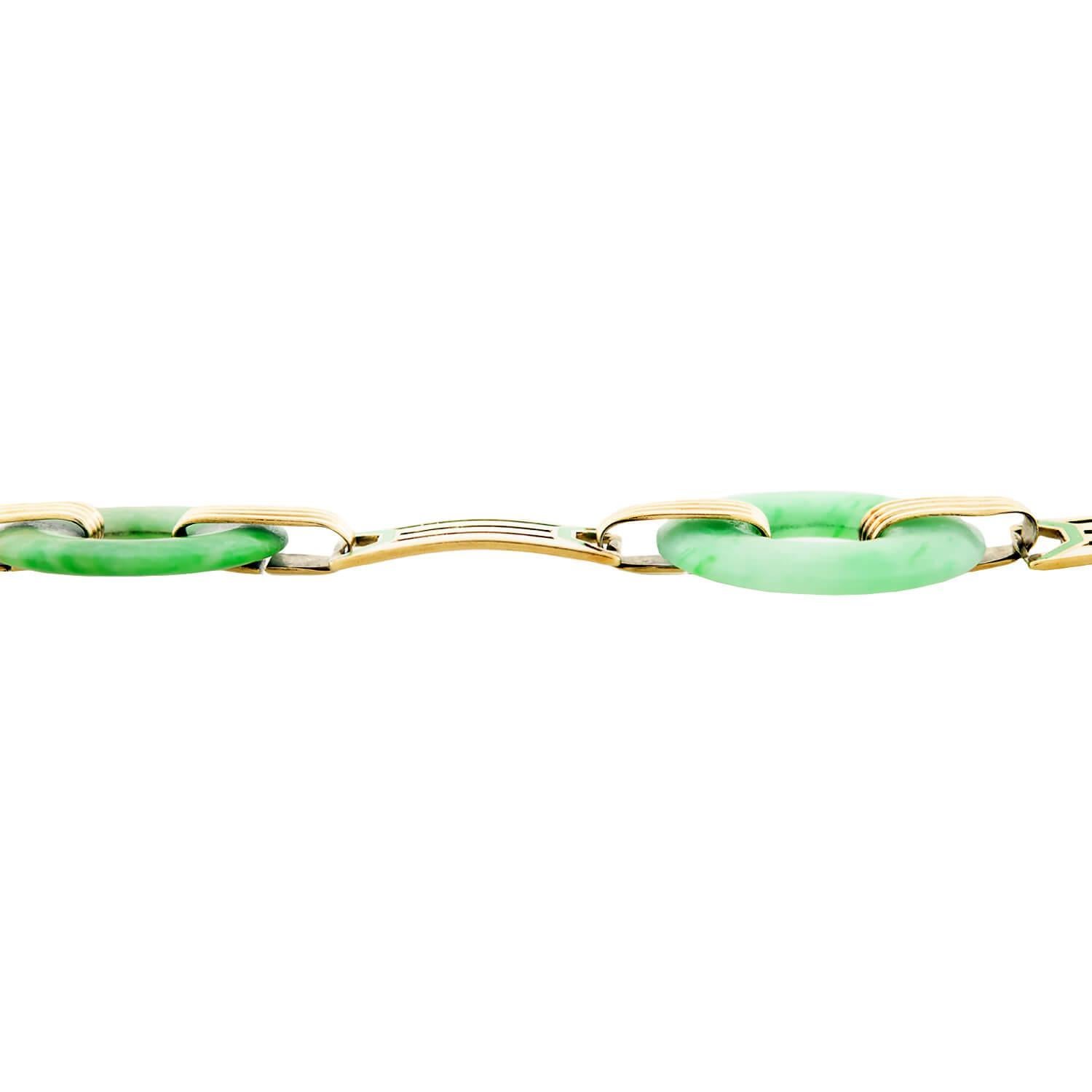 Un magnifique bracelet en jade de l'époque Art Déco (ca1920s) ! Cette pièce artistique est composée de trois disques circulaires en jade qui alternent avec des maillons émaillés de couleurs vives, formant ainsi un joli bracelet fluide. Fabriquée en