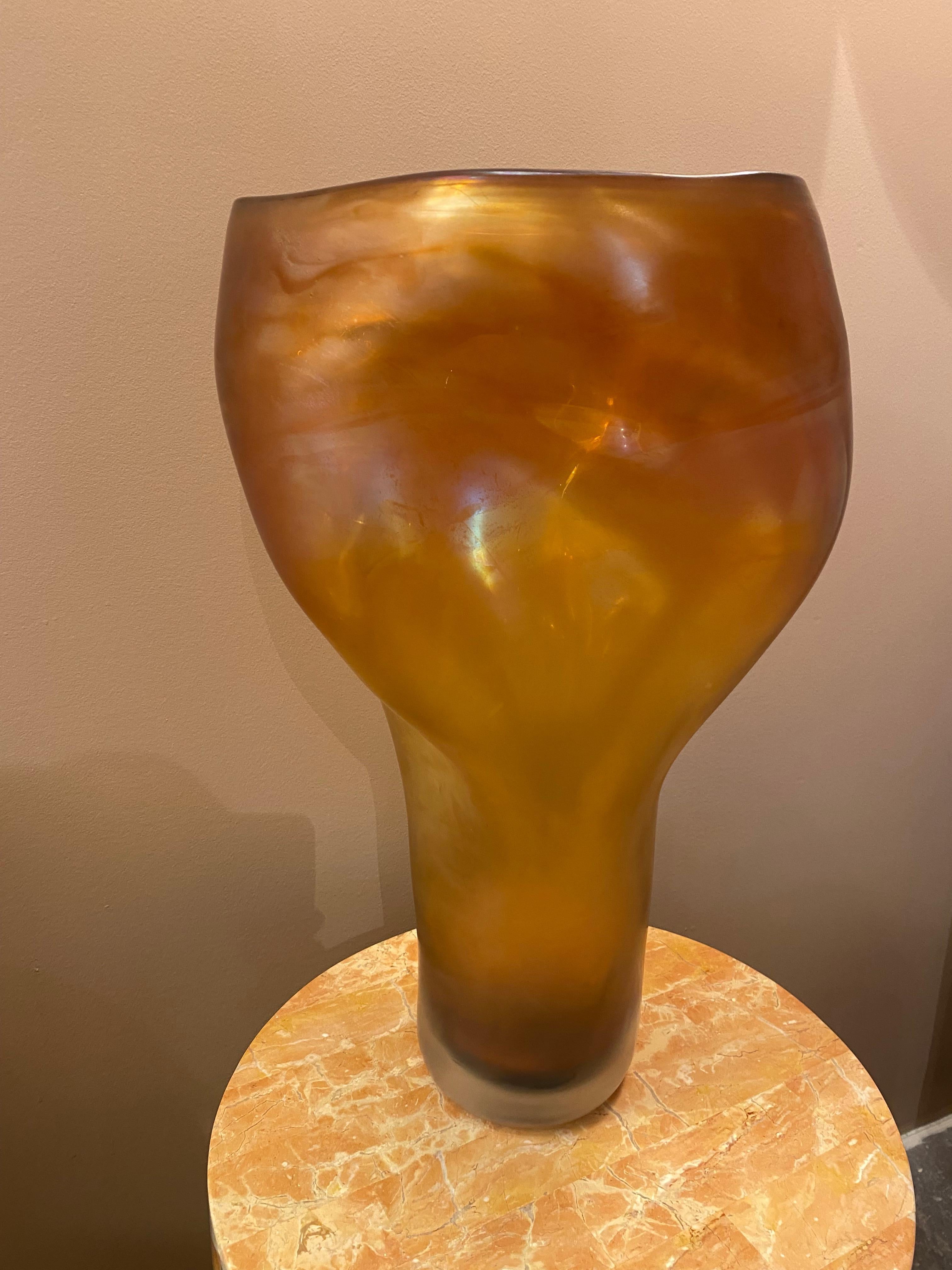 The ALLUNGATO vase is made by Massimo Micheluzzi using the process of Iridazione (to make a surface iridescent) that gives the glass a visual pearl-like effect. This chemical process is generated when the glass is still soft and