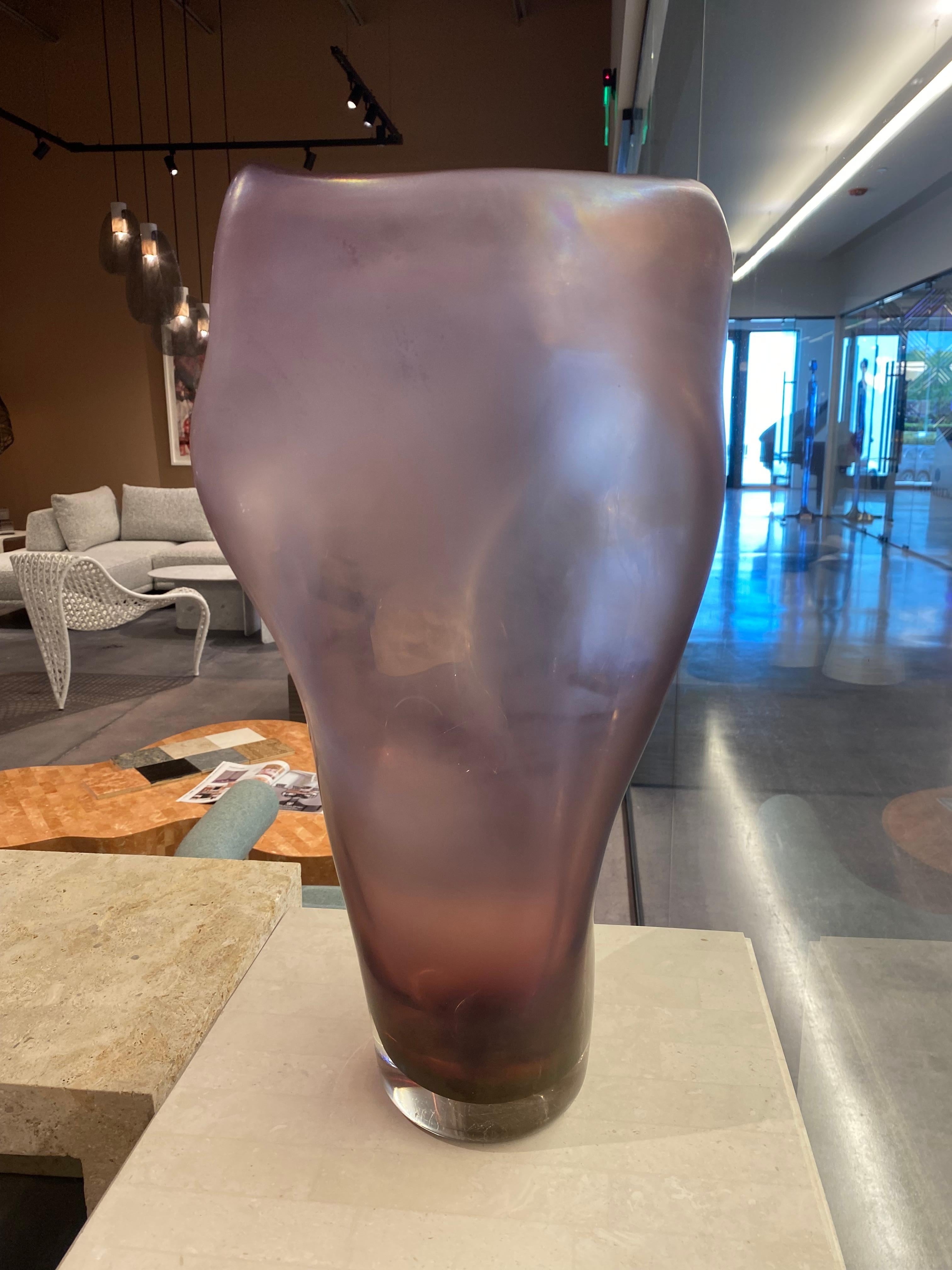 The ALLUNGATO vase is made by Massimo Micheluzzi using the process of Iridazione (to make a surface iridescent) that gives the glass a visual pearl-like effect. This chemical process is generated when the glass is still soft and