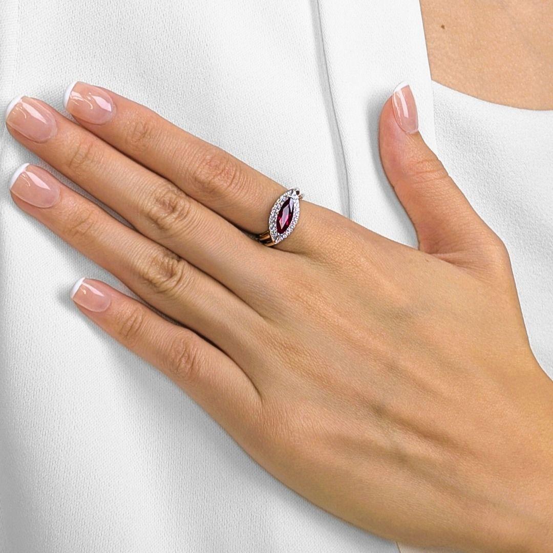 
This elegant ring showcases a vivid 1.34ct marquise-cut ruby, glowing with rich red brilliance as its centerpiece. Surrounding the ruby, 48 natural round brilliant diamonds (0.36ct total, G color, VS clarity) form a sparkling halo and cascade along