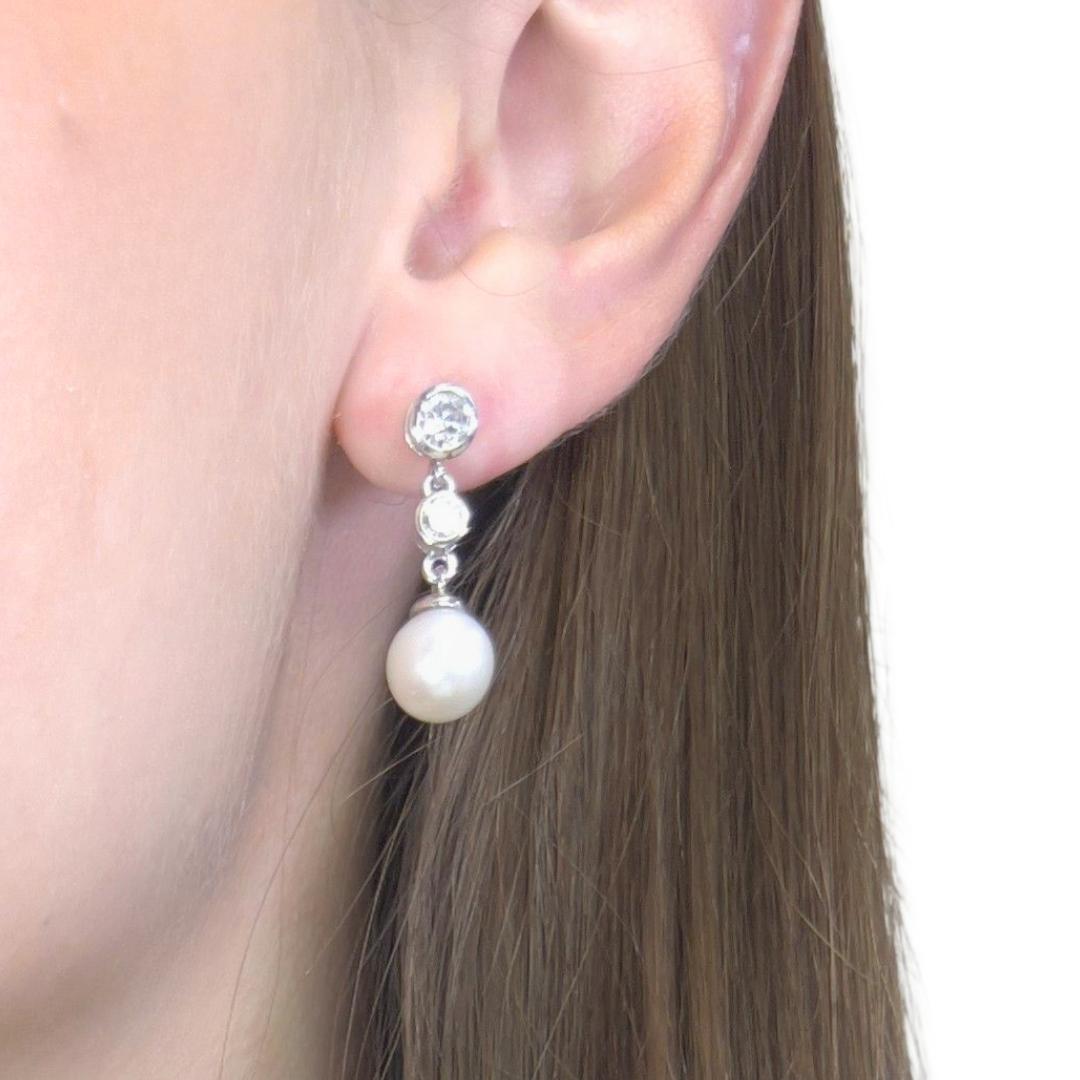 Alluring 9.35ct Fresh Water Cultured Pearls and Diamonds Drop Earrings in 18k White Gold - IGI Certified

These elegant 18K white gold drop earrings feature two luminous freshwater cultured pearls in a flawless round bead shape, radiating a timeless