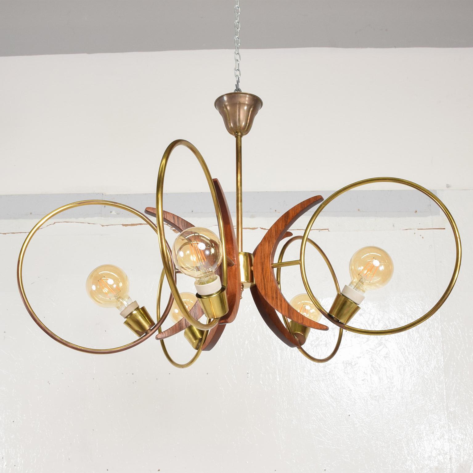 Modern Five Ring Swirling Sculptural Chandelier from Mexico City 1960s
Unmarked. Crisp Clean design.
Features five rings in patinated brass sculptural mahogany wood ornamentation.
33 in diameter x 22 tall inches.
Vintage patina on brass. 
Original