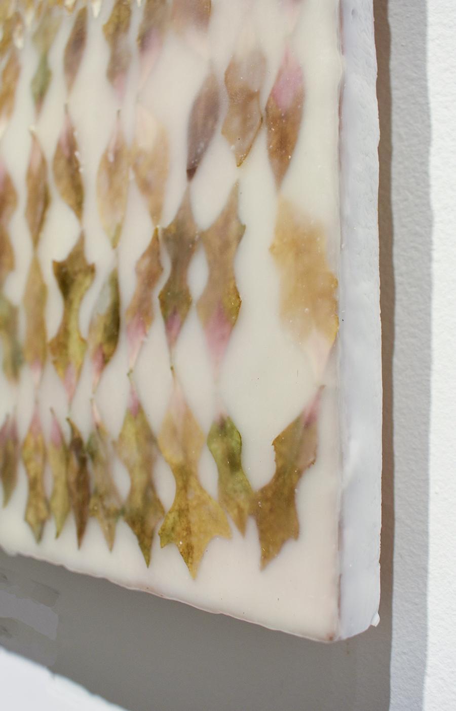 Abstract encaustic painting with green and neutral toned plant leaves on white encaustic over wood panel
