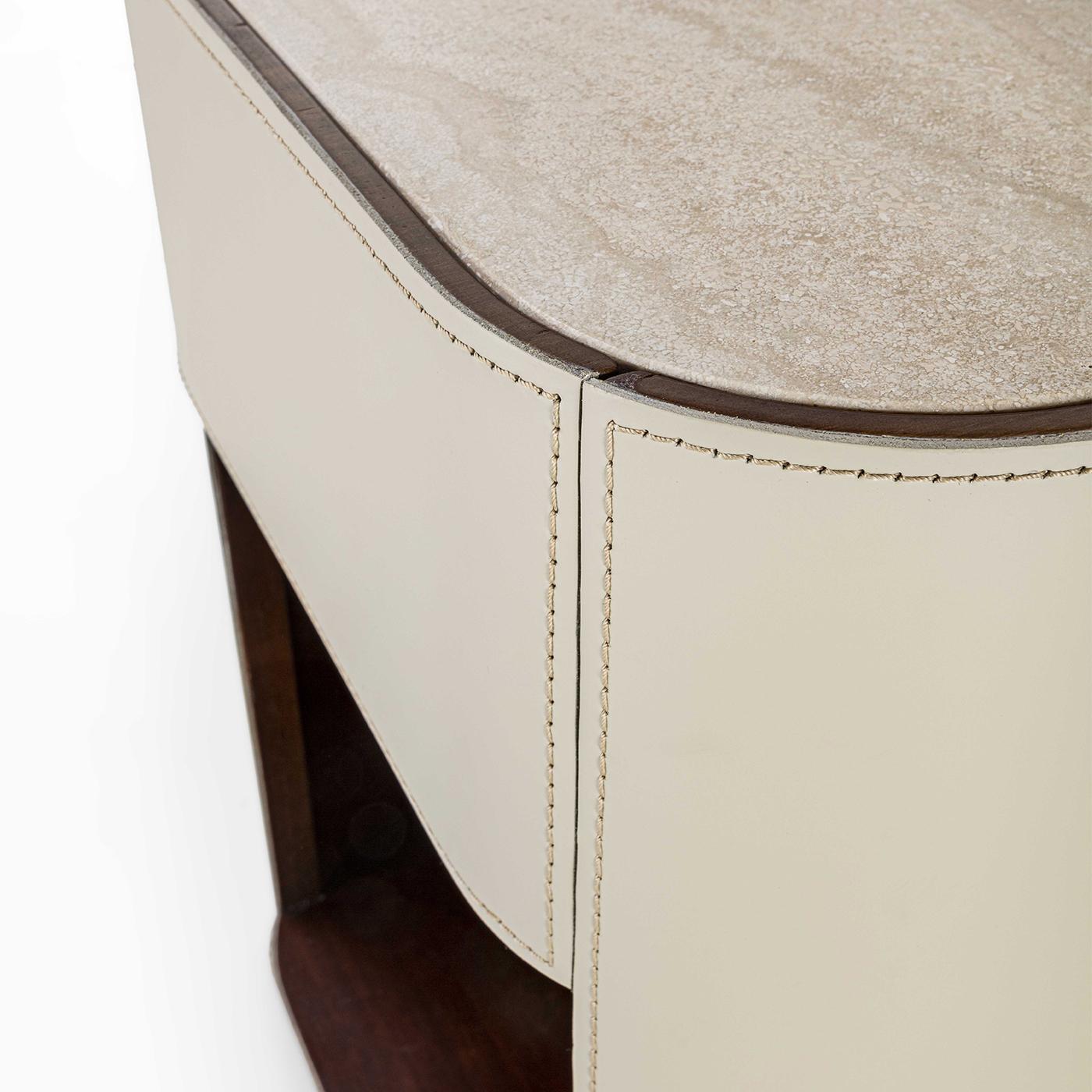 Prized materials daringly juxtaposed to a clean yet sinuous contemporary aesthetic define this luxurious nightstand. Its intoxicating sartorial allure is owed to the generous beige leather cover with contrast stitching. The warm Canaletto walnut
