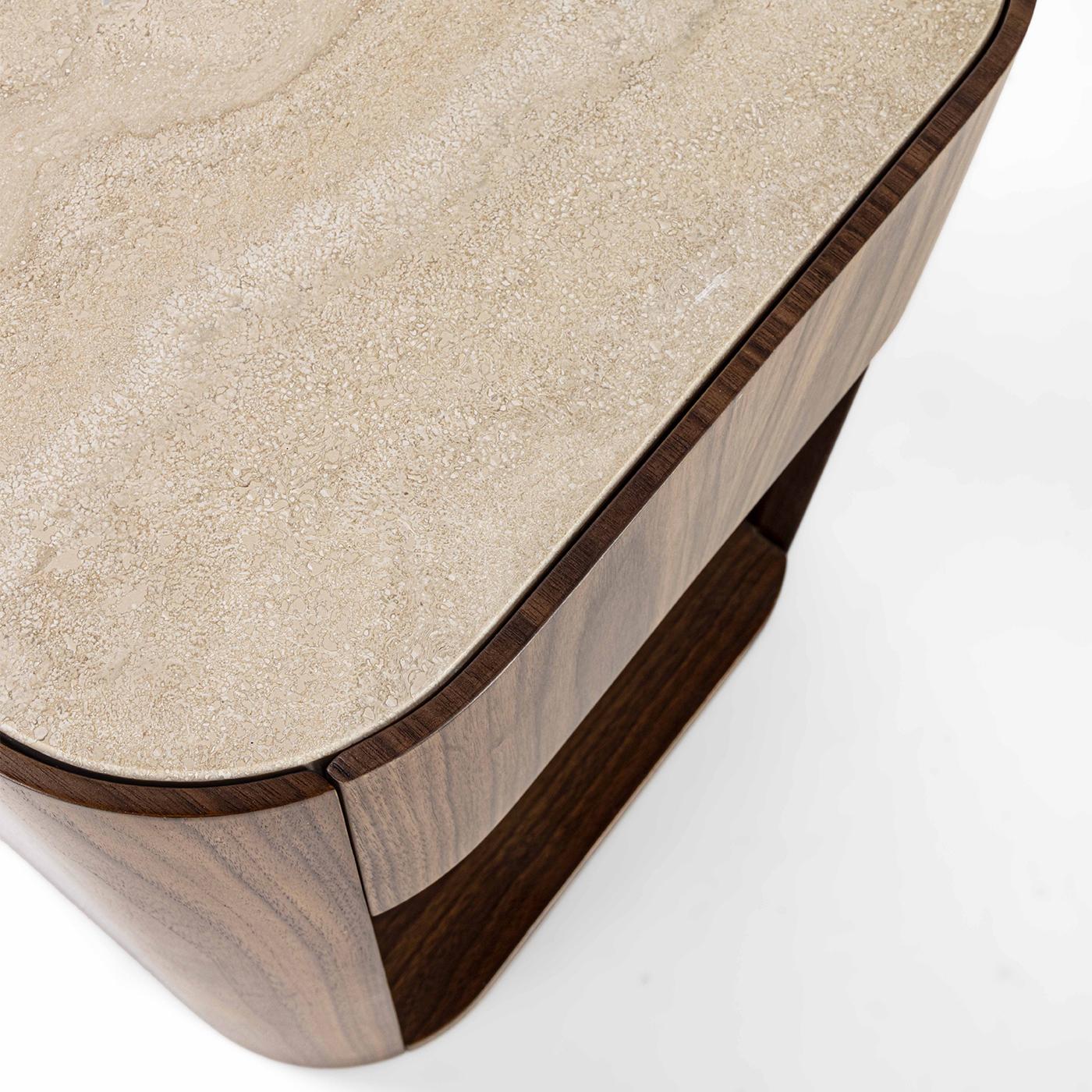 Rejecting sharp angularities in favor of subtle curves, this nightstand is an exquisite example of refined contemporary style. Singular swirls are showcased by its precious Canaletto Walnut structure, equipped with a wide open unit surmounted by a