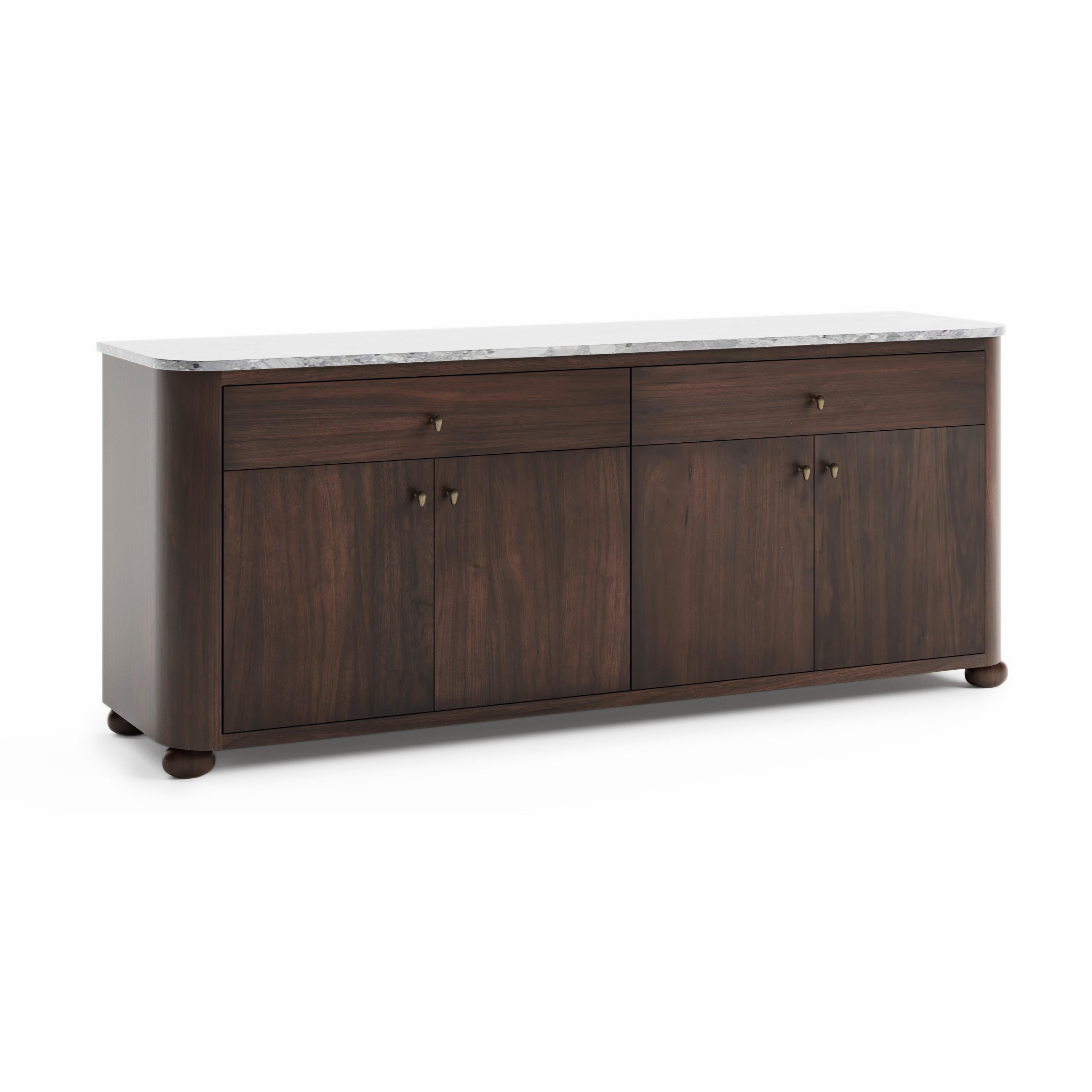 Ti presentiamo la Collection'S, uno studio di tranquilla eleganza. Il piano in marmo levigato conferisce un tono raffinato, mentre la ferramenta in bronzo invita a un sottile tocco di calore. La forma è sobria ma sorprendente: legno massiccio in una