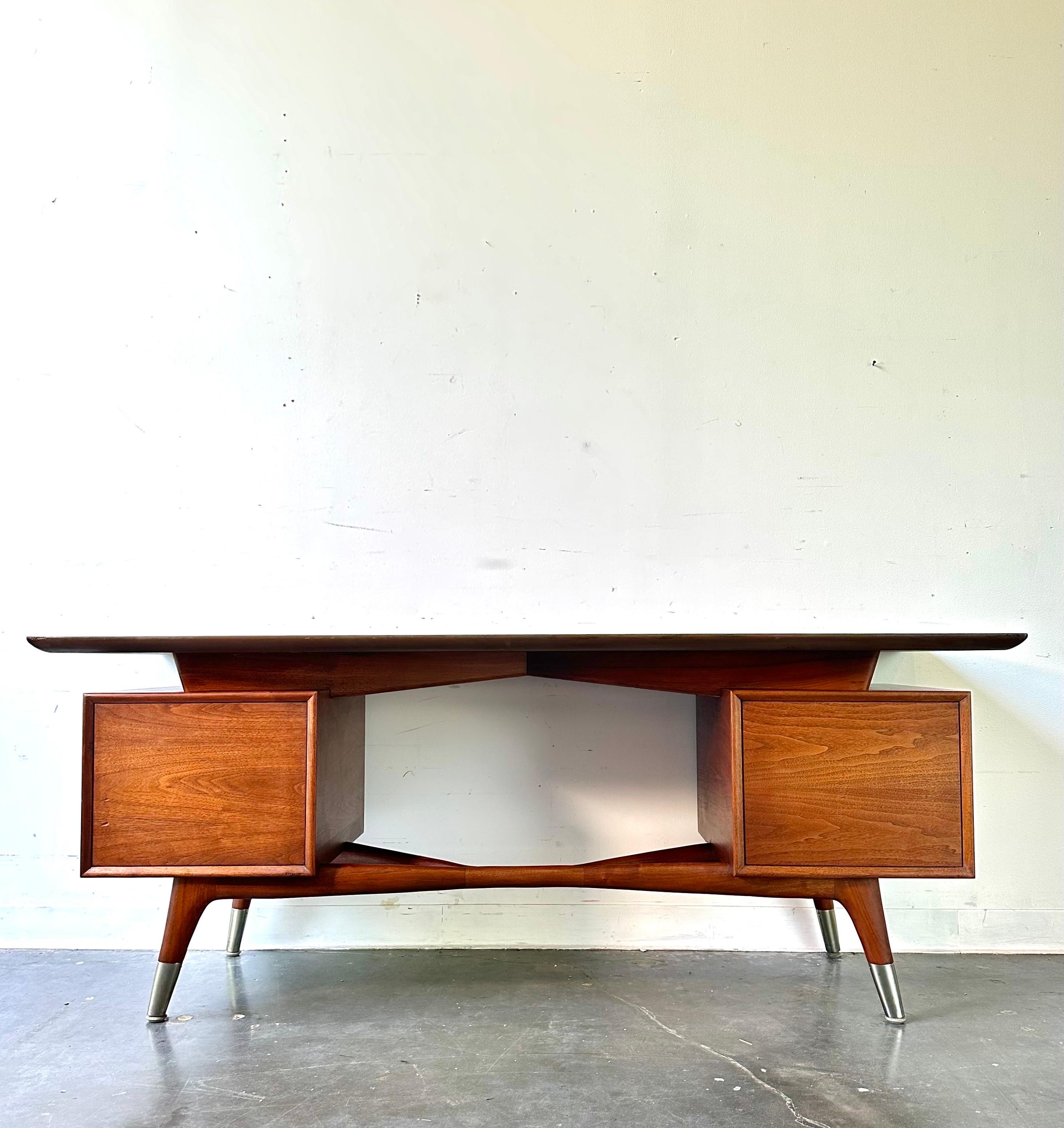 Very rare Skulptura desk by Alma.

Stunning sculptural executive desk with x base and wood grain. 

Sleek lines, one large drawer, and one shelf behind. Tambour door.

Dimensions:
72” L x 24” D x 28” H.