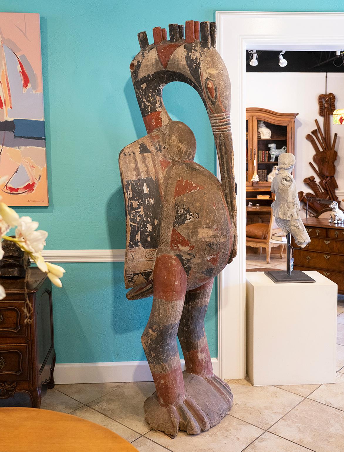 This Giant bird sculpture by the Senufo People of Cote d'ivoire in Africa has its inspiration from the Yellow-Casgued Hornbill. The main composition is dominated by a phallic curved beak pointing to a pregnant stomach indicating a procreation theme