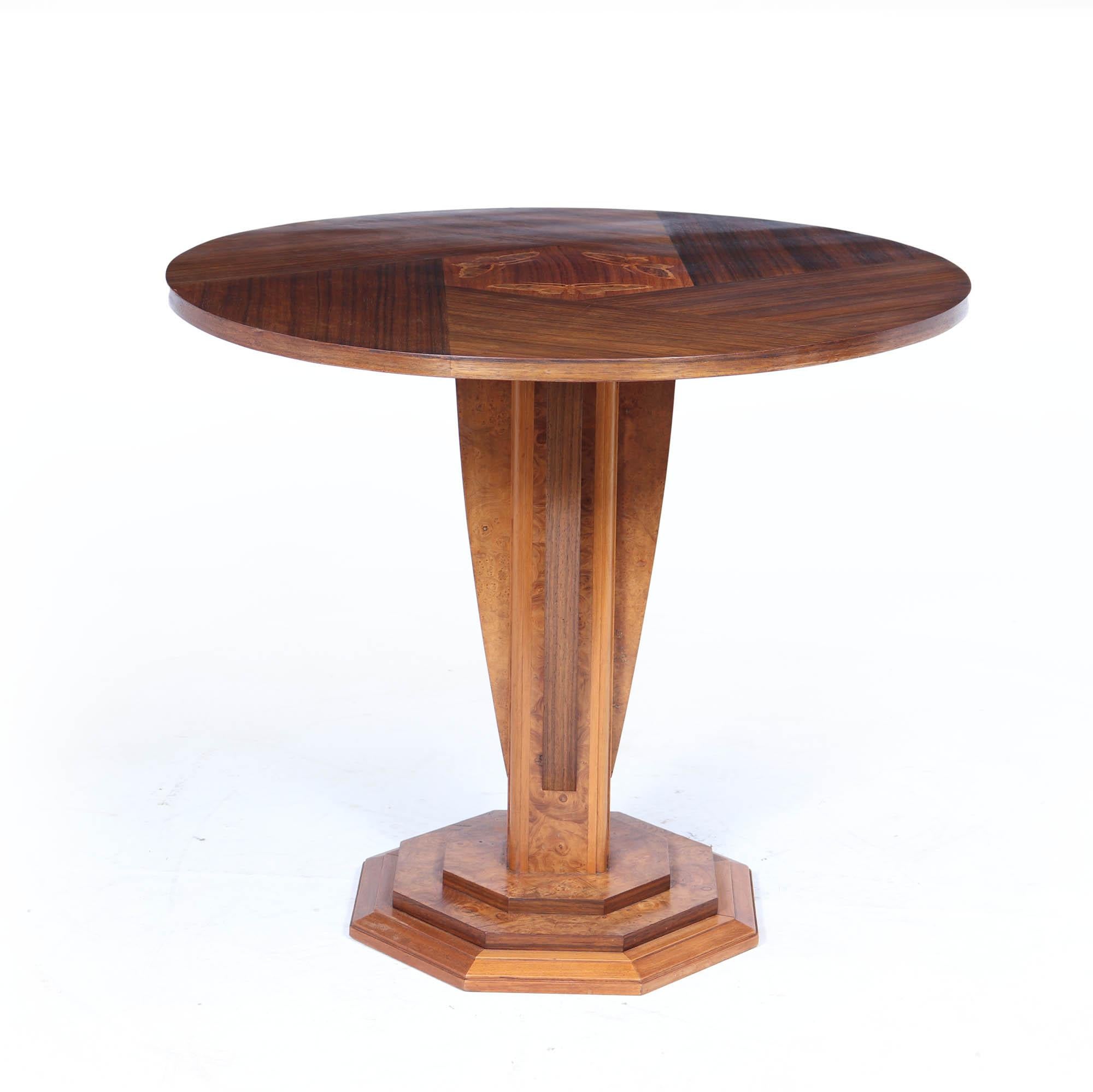 Un guéridon rond aux proportions magnifiques et aux détails raffinés de l'école de Nancy, fabriqué en ronce de noyer et en bois de rose, avec un motif de marqueterie incrusté de trois papillons de nuit au centre. Signée par le fabricant, cette pièce