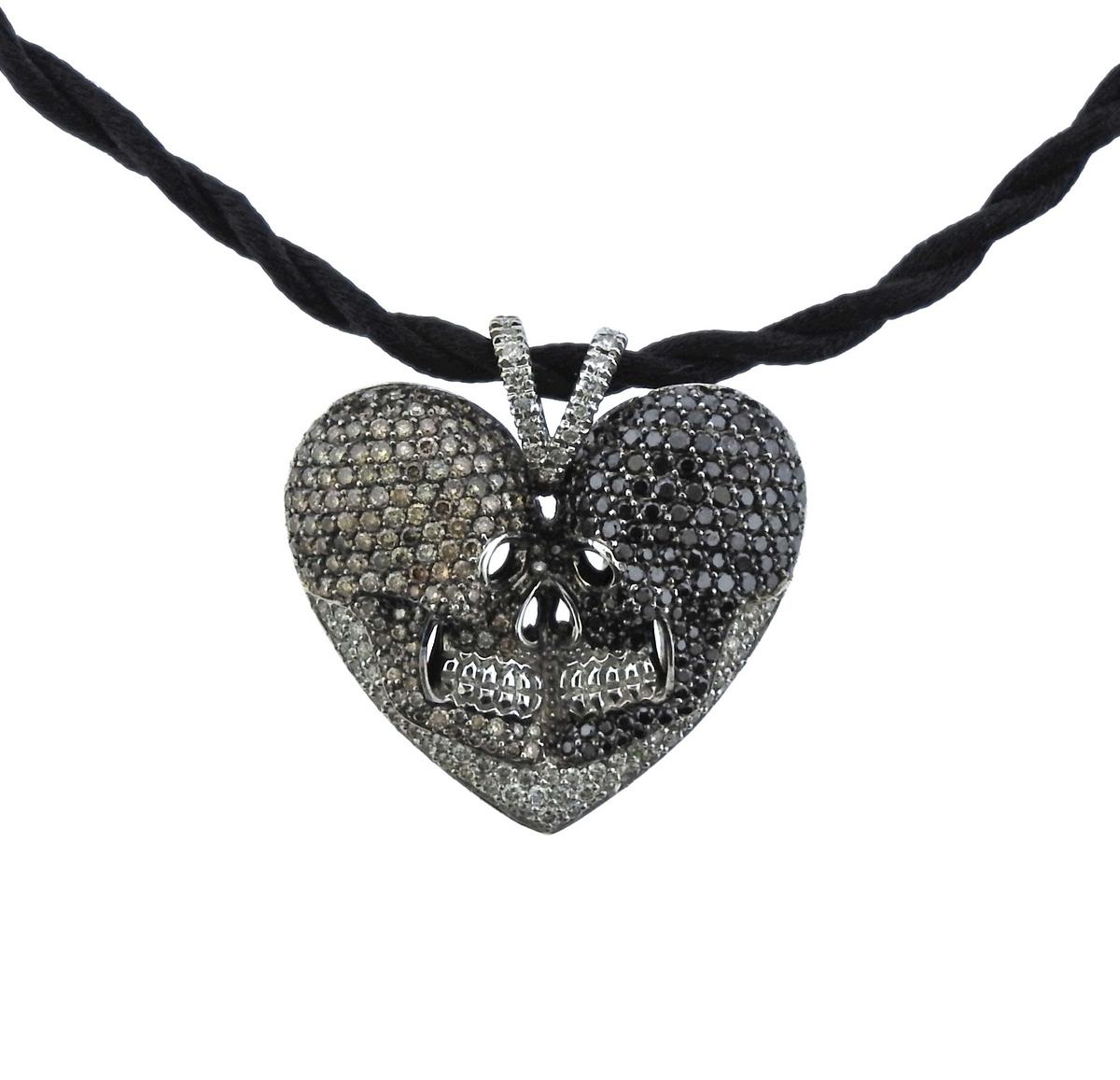 Alp Sagnak 18k gold heart pendant, set with black sapphires and approx. 1.70ctw in white and fancy brown diamonds. Suspended on a black cord necklace. Necklace is 18.25