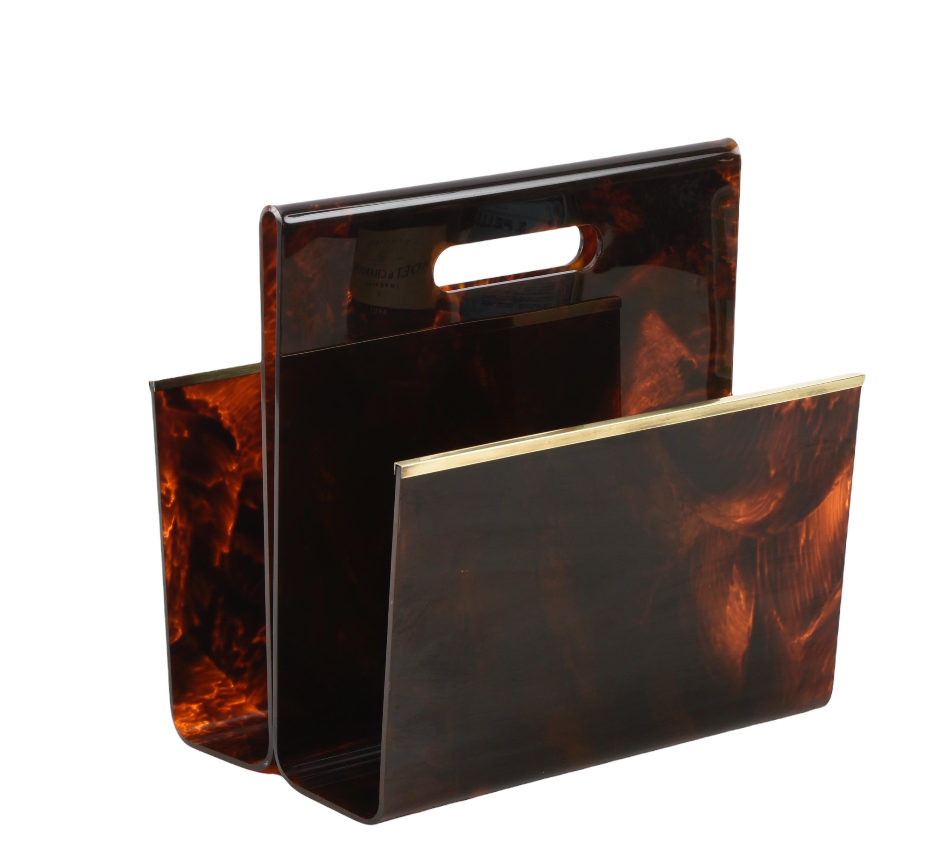 Wonderful faux tortoiseshell plexiglass magazine rack with brass edges. This fantastic piece was designed by Creation ALPAC and made in France during the 1970s. 

This unique magazine rack has been beautifully crafted to give it the look of