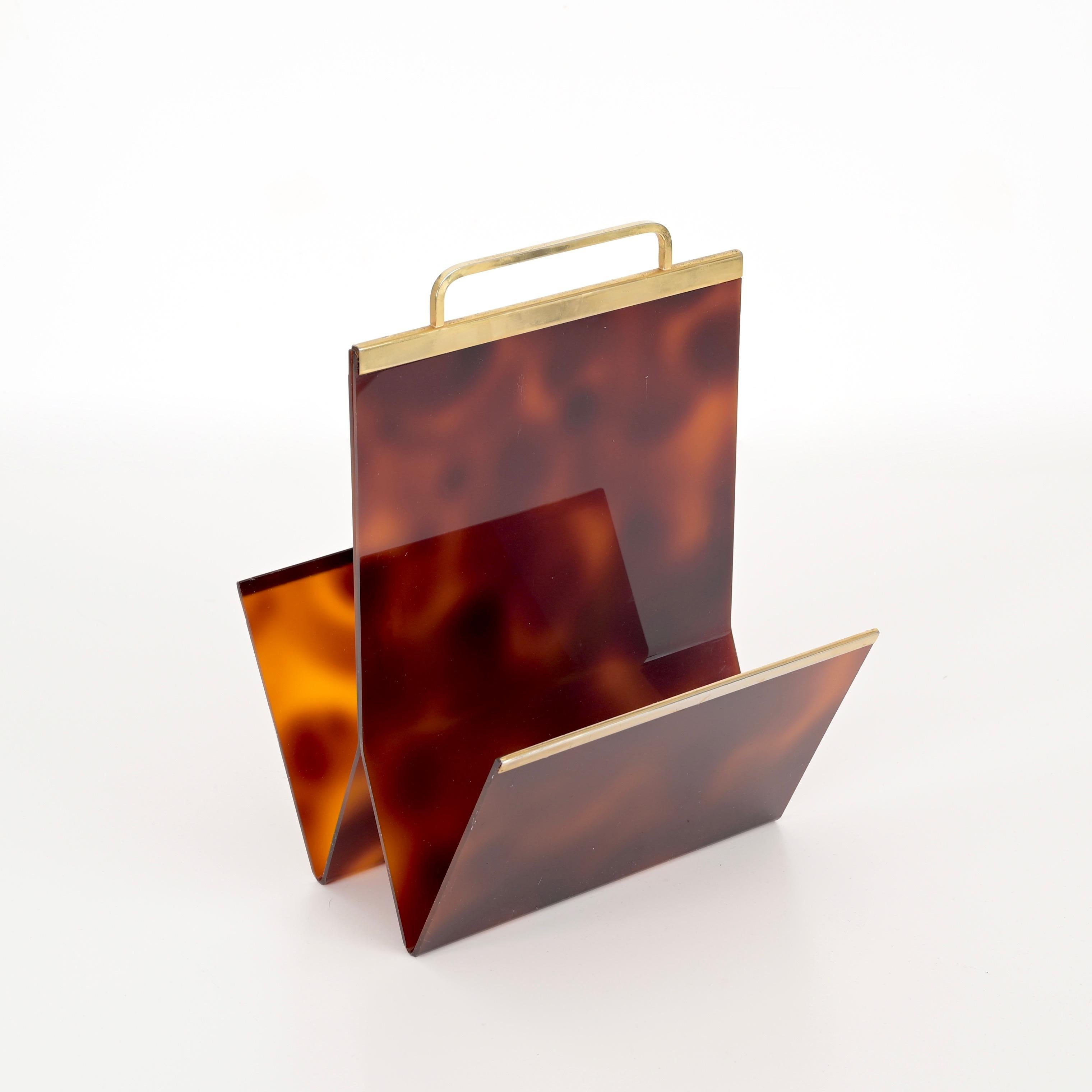 Wonderful Mid-Century magazine rack in tortoiseshell effect lucite and brass. This incredibly elegant piece was designed by Creation ALPAC, clearly in the style of a Christian Dior production and made in France during the 1970s.. 

This unique