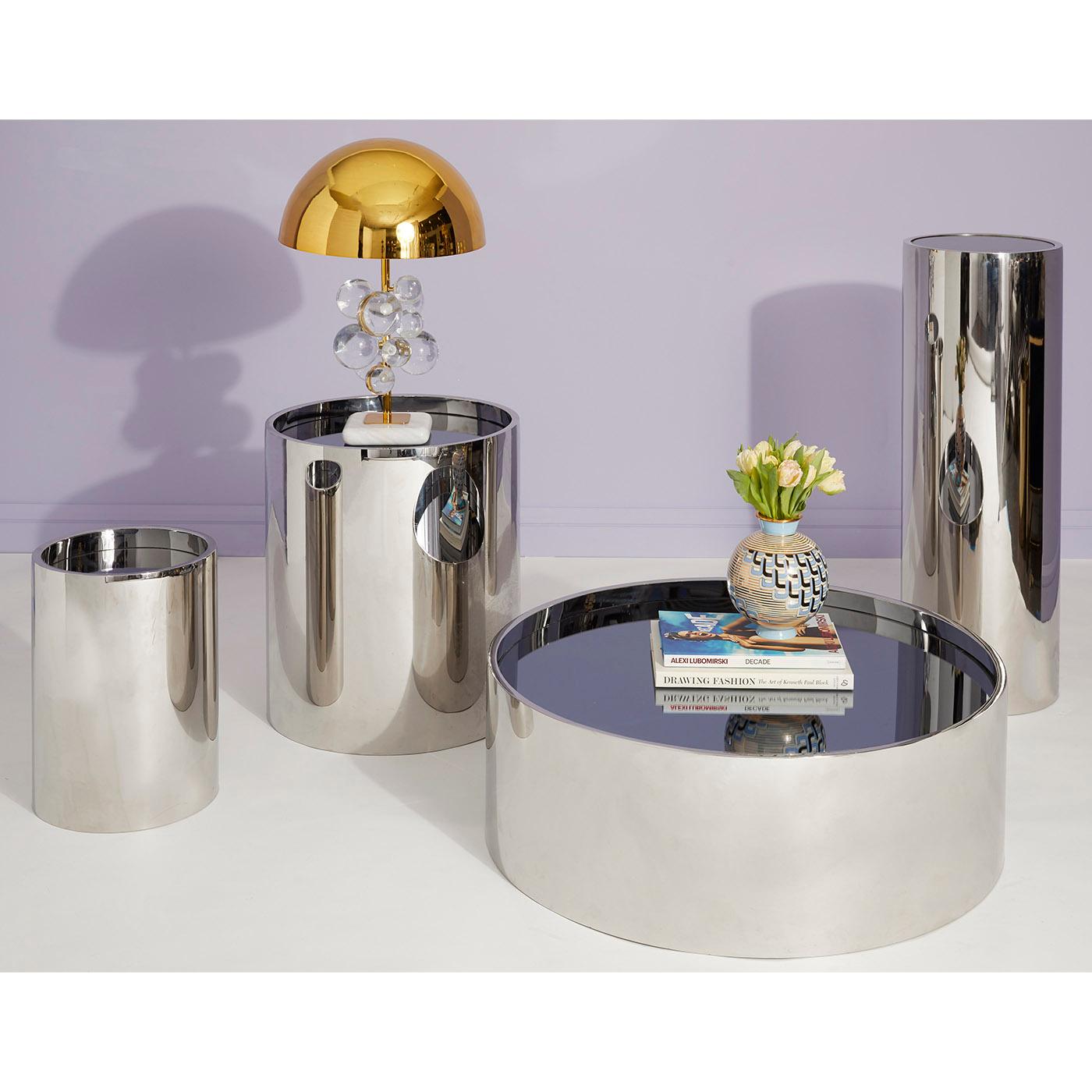 Futuristic reflection. Minimalist and modern, solid and simplified: polished stainless steel with a smoke mirror top. Our Alphaville Pedestal is a decorator's secret weapon—place a vibrant vase or bold bust on top, plunk it in an unused corner or in